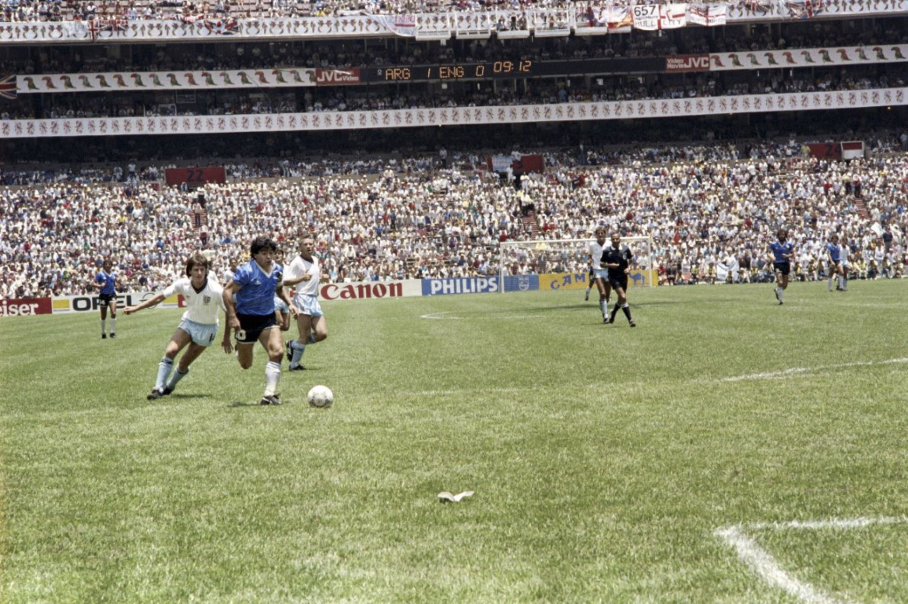 El mediocampista argentino Diego Maradona regatea a dos defensores ingleses el 22 de junio de 1986 en la Ciudad de México durante el partido de cuartos de final de la Copa del Mundo entre Argentina e Inglaterra. Maradona anotó dos goles, el primero con la mano izquierda cuando saltó hacia el balón frente al portero Peter Shilton, mientras Argentina venció a Inglaterra 2-1. Foto: AFP
