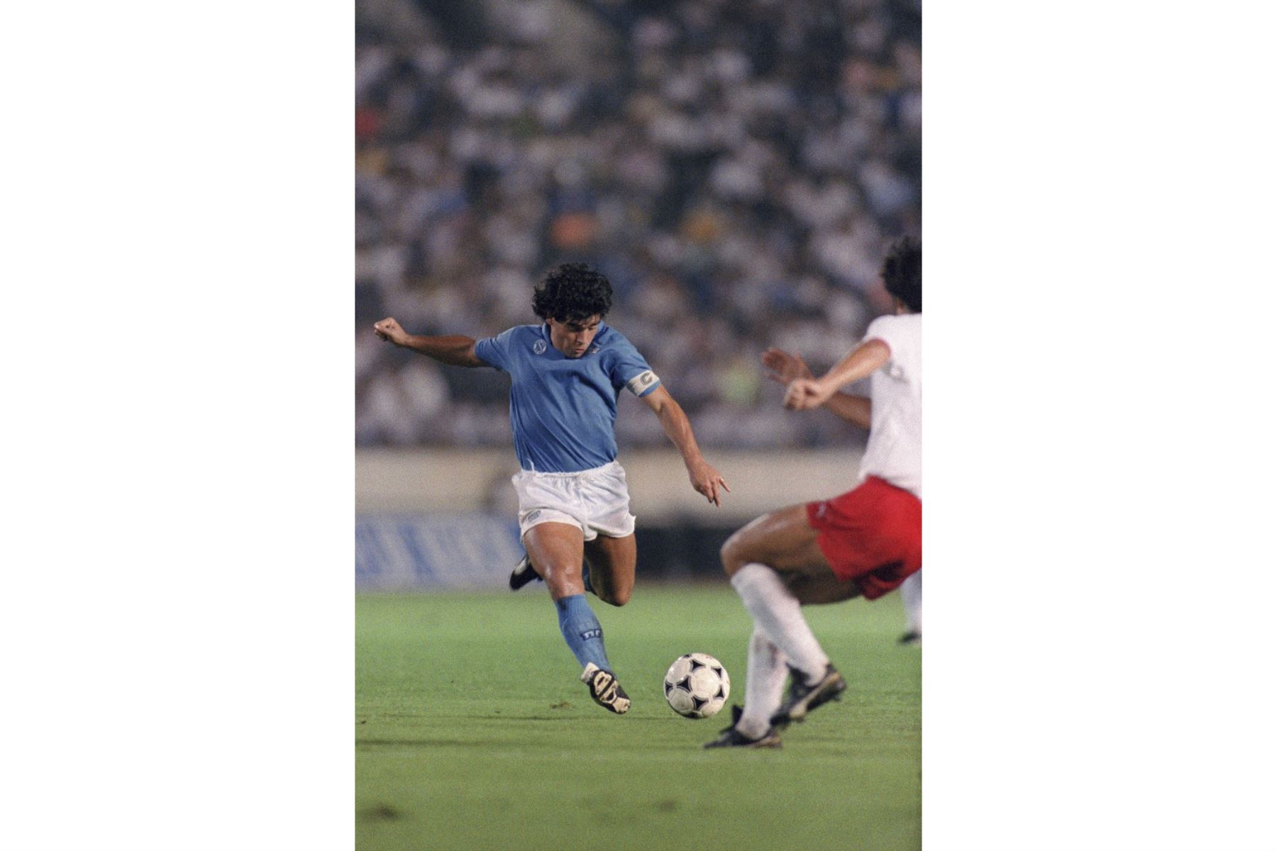 La superestrella del fútbol argentino Diego Maradona (L) de S.S.C Napoli está a punto de disparar un balón a la portería durante el Xerox Super Soccer el 12 de agosto de 1988 contra la Selección Nacional de Japón en Tokio. Napoli ganó el juego 2-0.  Foto: AFP