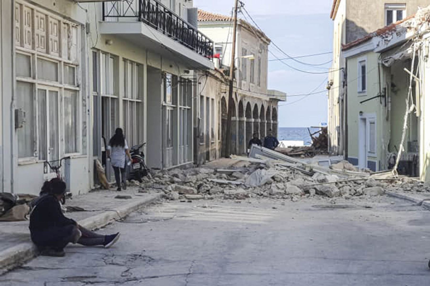 La gente pasa junto a una casa destruida después de un terremoto en la isla de Samos en Grecia. Foto: AFP