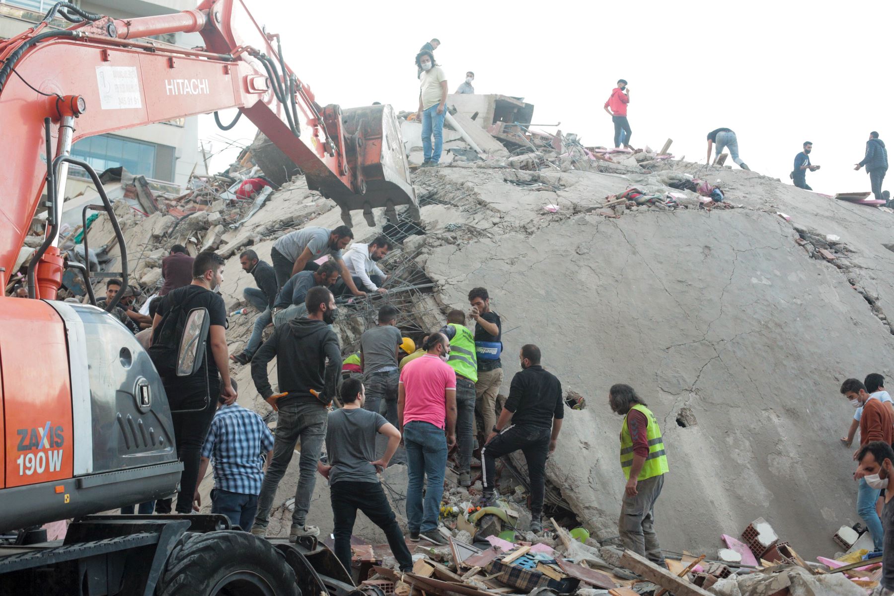 Los voluntarios limpian los escombros mientras buscan sobrevivientes en un edificio derrumbado después de que un fuerte terremoto sacudió la costa occidental del país y partes de Grecia, matando a cuatro personas e hiriendo a 120, en Izmir. Foto: AFP