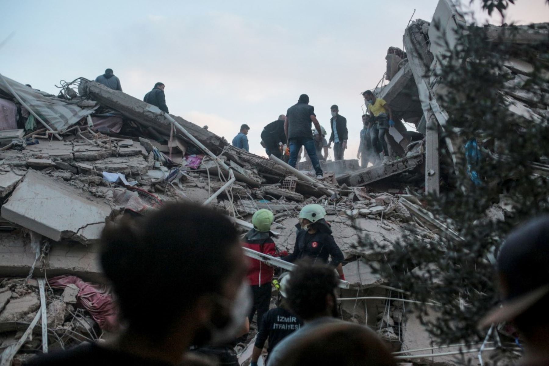 Los voluntarios limpian los escombros mientras buscan sobrevivientes en un edificio derrumbado después de que un fuerte terremoto sacudió la costa occidental del país y partes de Grecia, matando a cuatro personas e hiriendo a 120, en Izmir. Foto: AFP