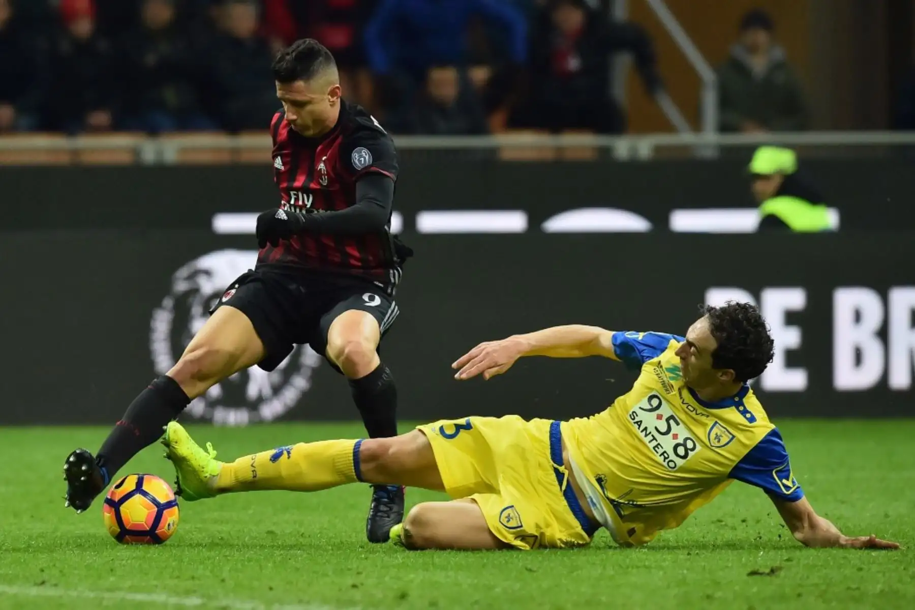 El defensor del Chievo de Italia lucha por el balón con el delantero del AC Milan de Italia Gianluca Lapadula durante el partido de fútbol de la Serie A italiana. Foto: AFP