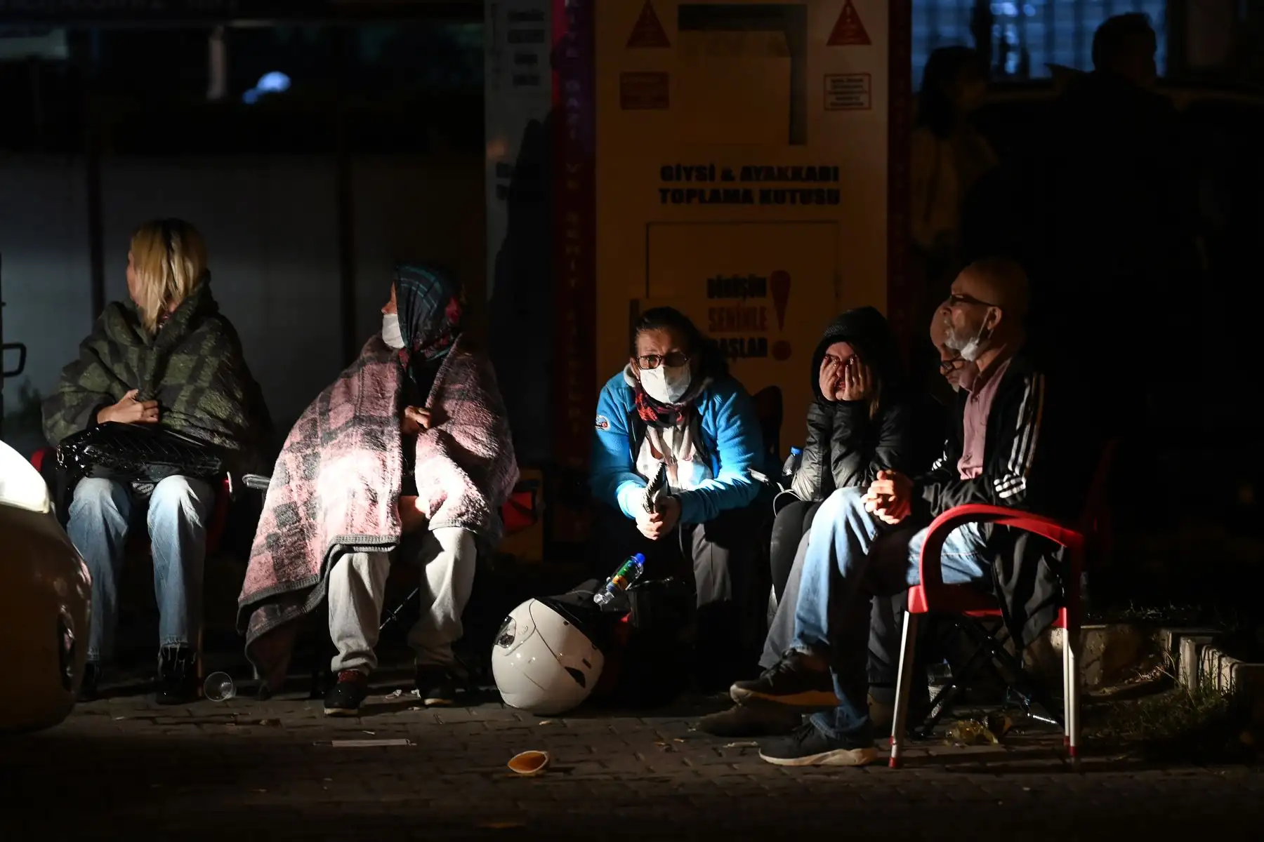 La gente espera mientras los rescatistas buscan sobrevivientes entre los escombros de un edificio derrumbado después de que un poderoso terremoto azotara la costa occidental de Turquía y parte de Grecia, en Izmir. Foto: AFP