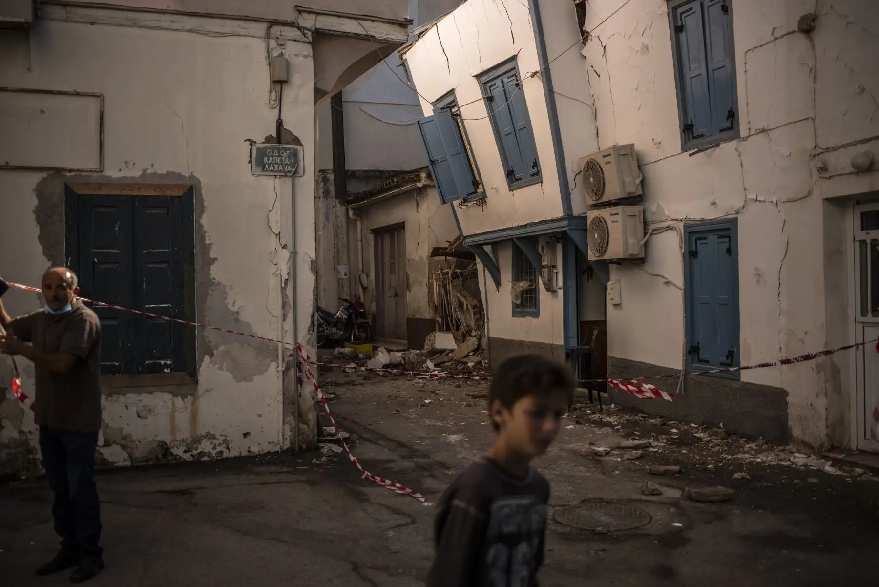 Los residentes transitan junto a los edificios dañados en una calle del pueblo de Vathy, el 31 de octubre de 2020, un día después de que un poderoso terremoto azotara parte de Grecia y la costa occidental de Turquía. Foto: AFP