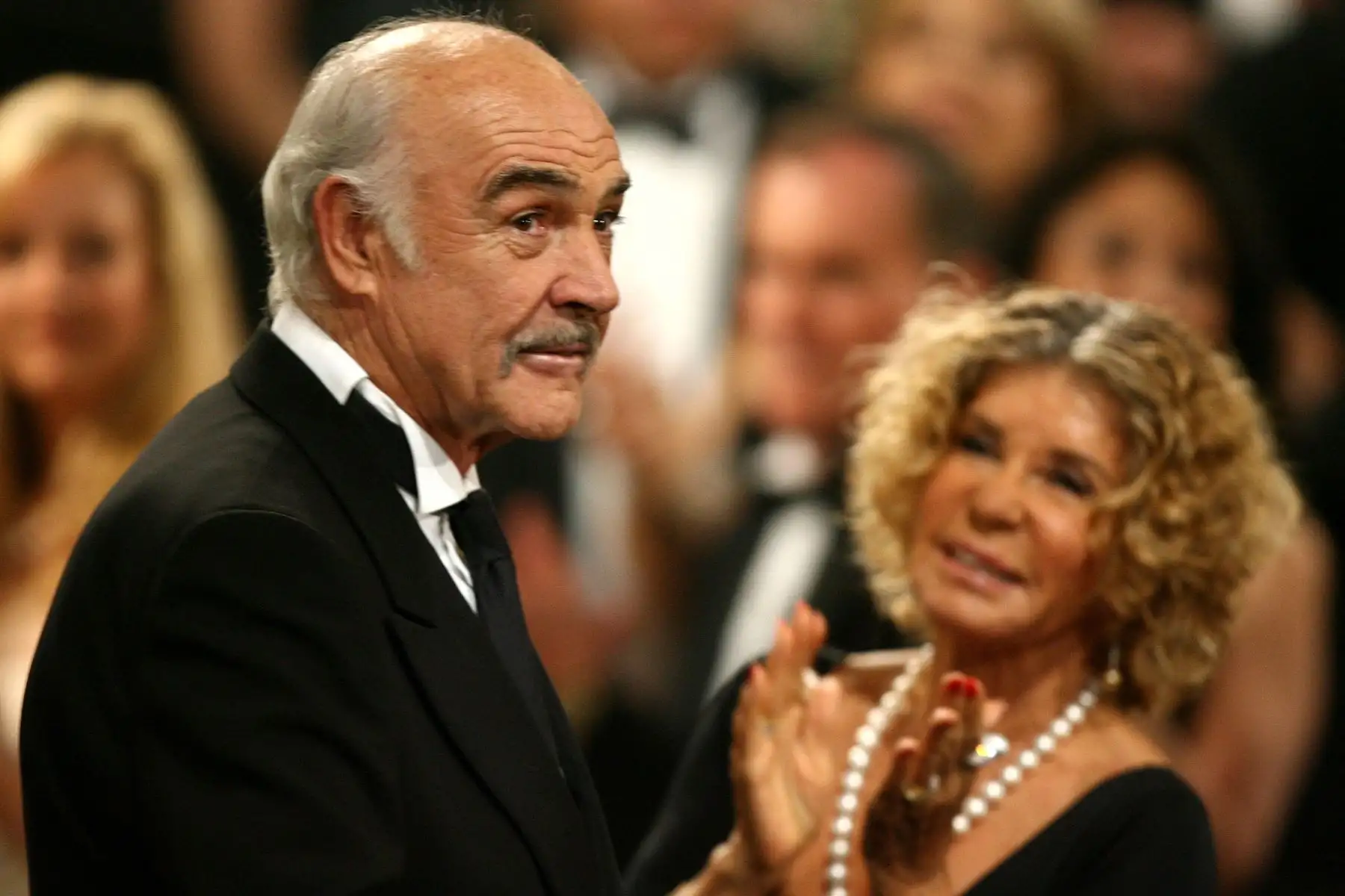 El actor Sean Connery reacciona a la audiencia con su esposa Micheline Roquebrune durante el 34 AFI Life Achievement Award en su homenaje celebrado en el Teatro Kodak, el 8 de junio de 2006 en Hollywood. Foto: AFP