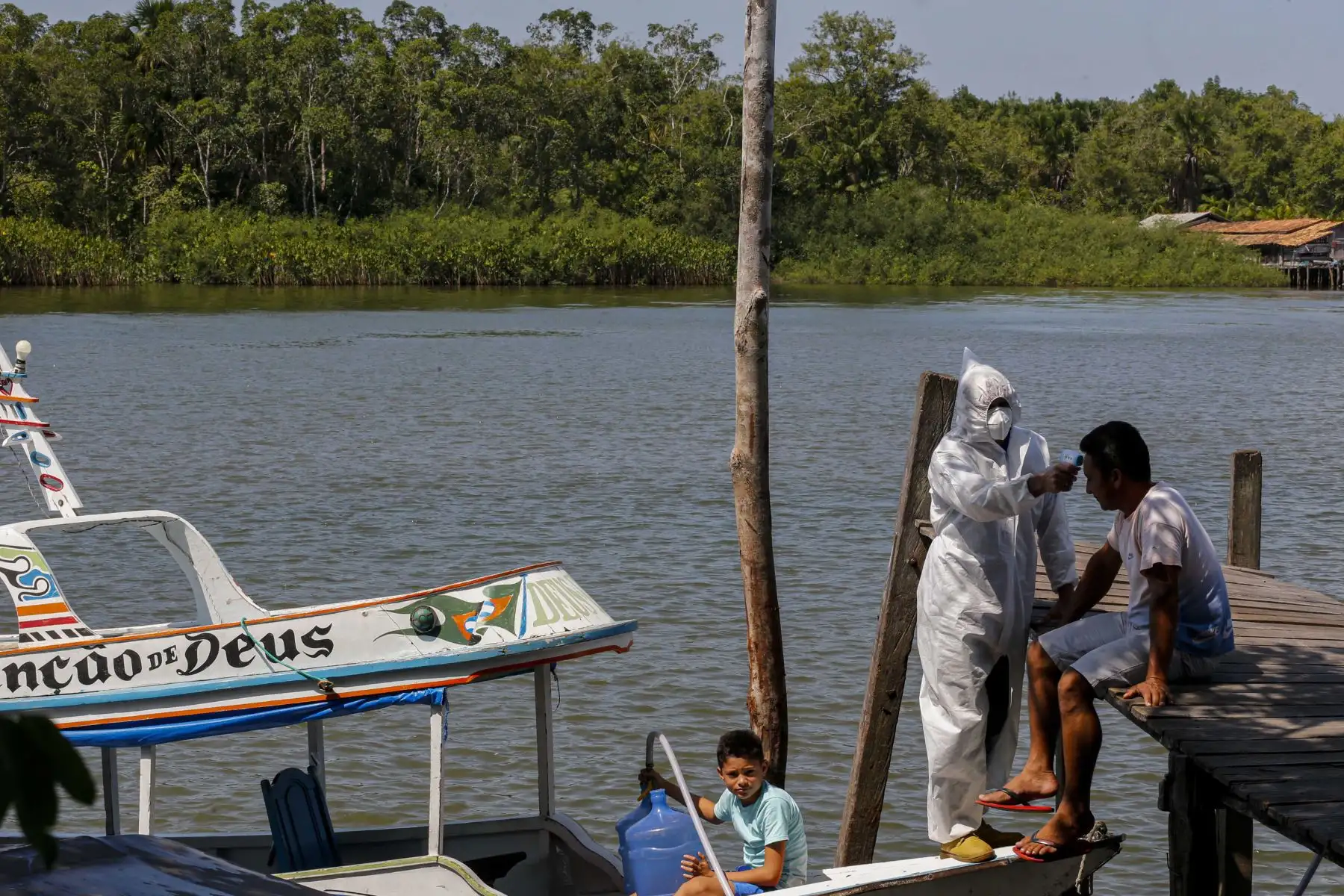Un trabajador de salud mide la temperatura de los residentes ribereños en la comunidad de Pindobal en el municipio de Igarape-Miri, región del bajo Tocantins, al noreste del estado de Pará, Brasil. Foto: AFP