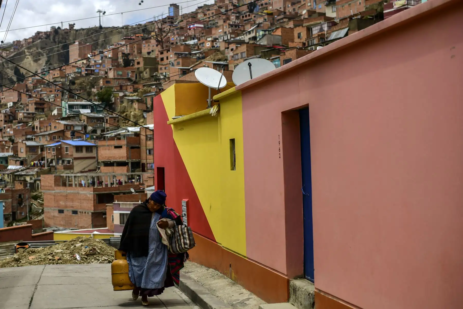 Una mujer camina en una calle del barrio de Chualluma en La Paz en medio de la nueva pandemia por coronavirus. Foto: AFP