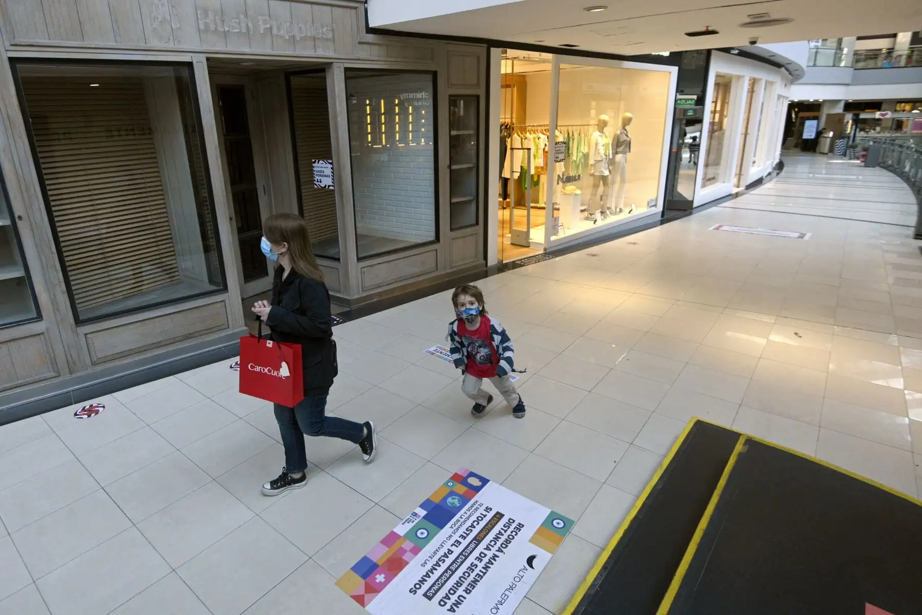 Una mujer y un niño visitan un centro comercial de Buenos Aires, el 14 de octubre de 2020, en su reapertura en medio de la pandemia por coronavirus. Foto: AFP