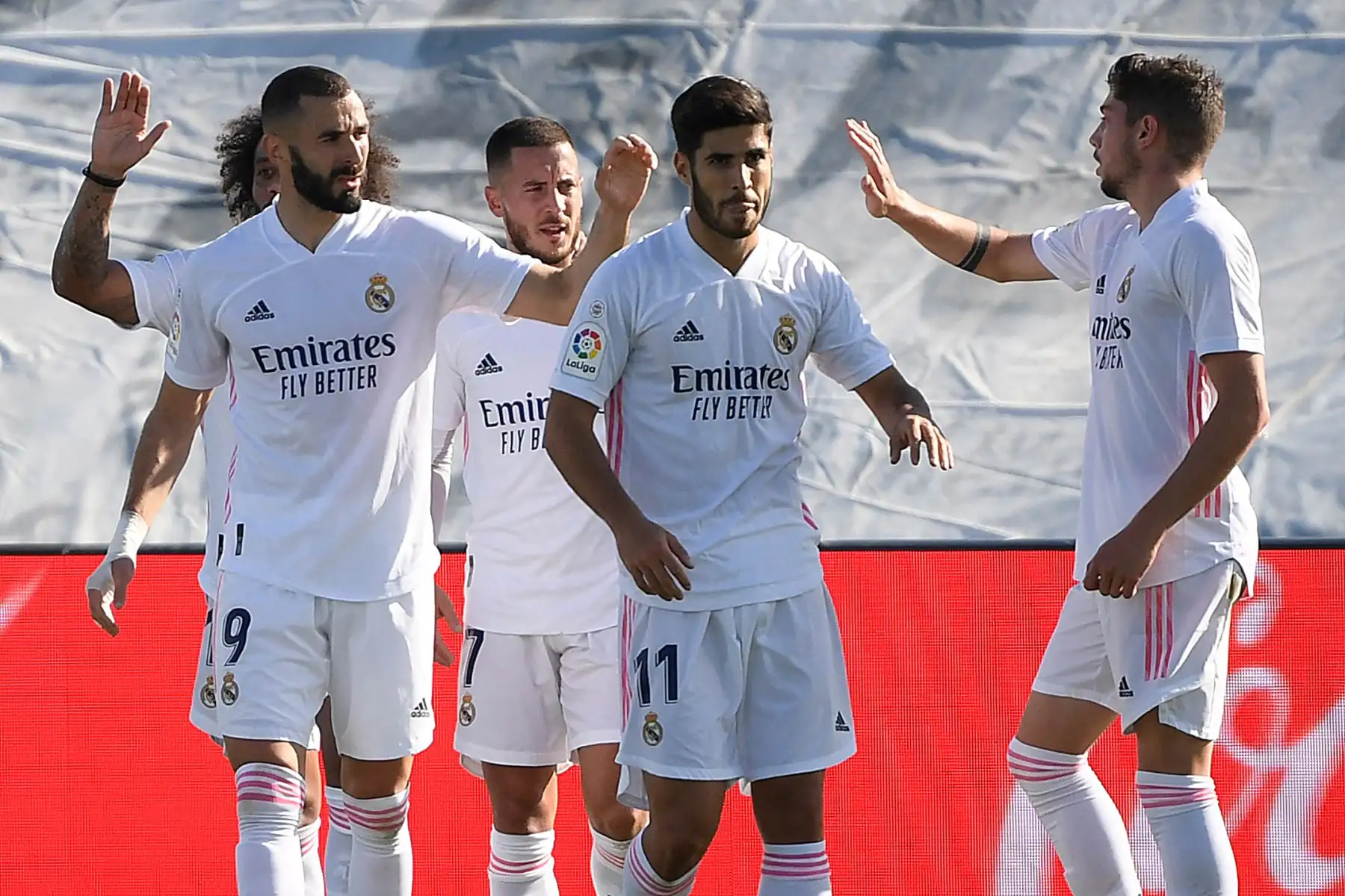 El delantero francés del Real Madrid Karim Benzema celebra con sus compañeros tras anotar el segundo gol de su equipo durante el partido de fútbol contra la SD Huesca de la Liga española. Foto: AFP