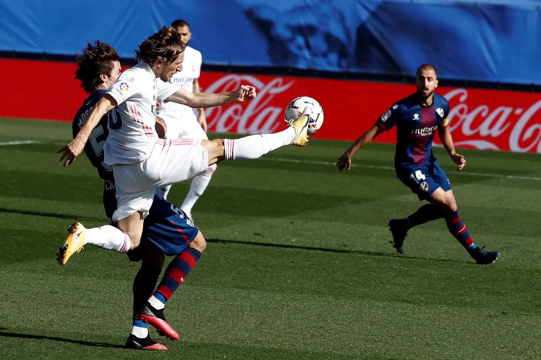 El centrocampista croata del Real Madrid, Luka Modric, lucha por el balón contra el centrocampista Pedro Mosquera del SD Huesca durante el partido correspondiente a la octava jornada de LaLiga, en el estadio Alfredo Di Stéfano. Foto: EFE