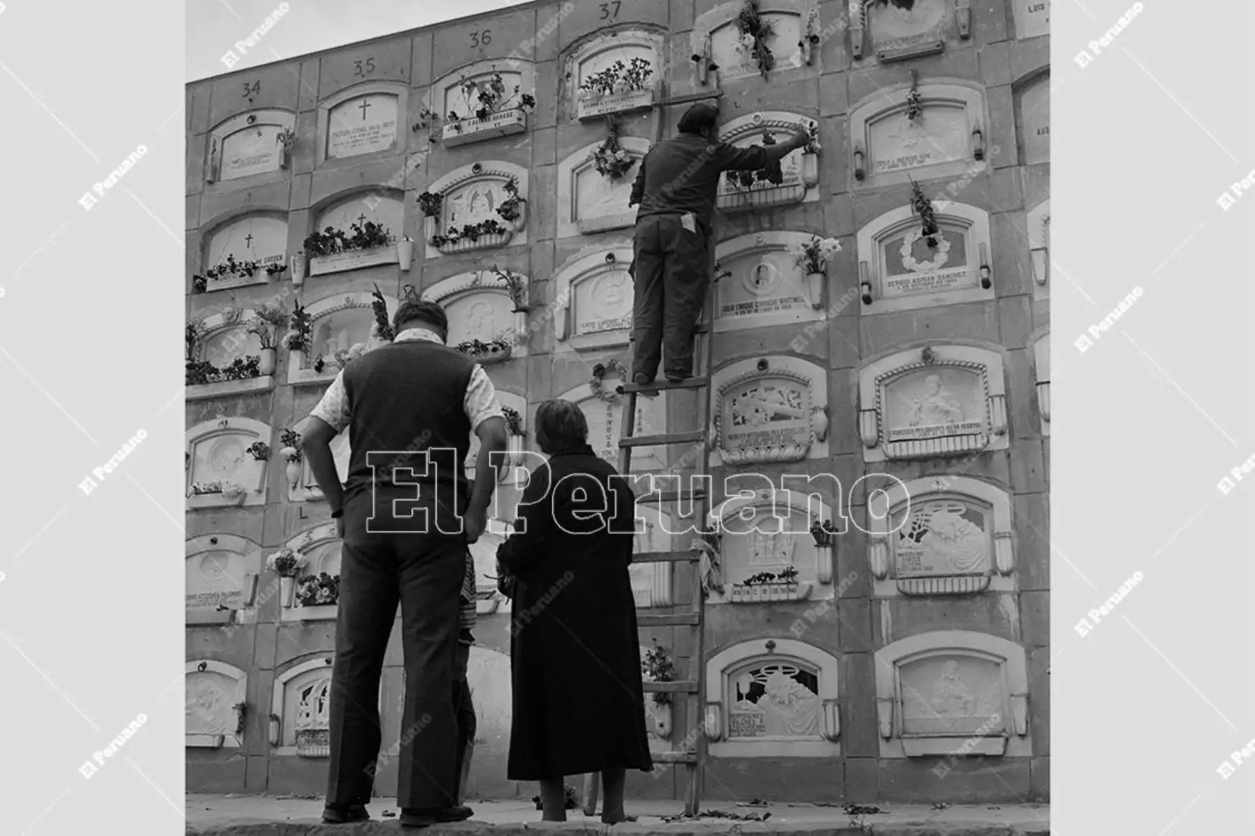 Lima - 1 noviembre 1974. Una pareja de ancianos encarga poner flores en l el nicho de un familiar en el cementerio El Ángel.  Foto: Archivo Histórico de El Peruano / Norman Córdova