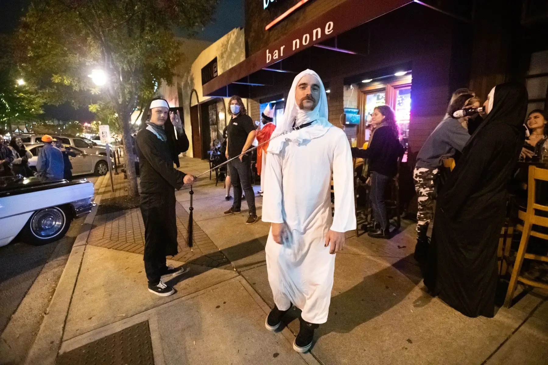 Personas con disfraces de Halloween en las afueras de un par en Five Points en Columbia, Carolina del Sur. Foto: AFP