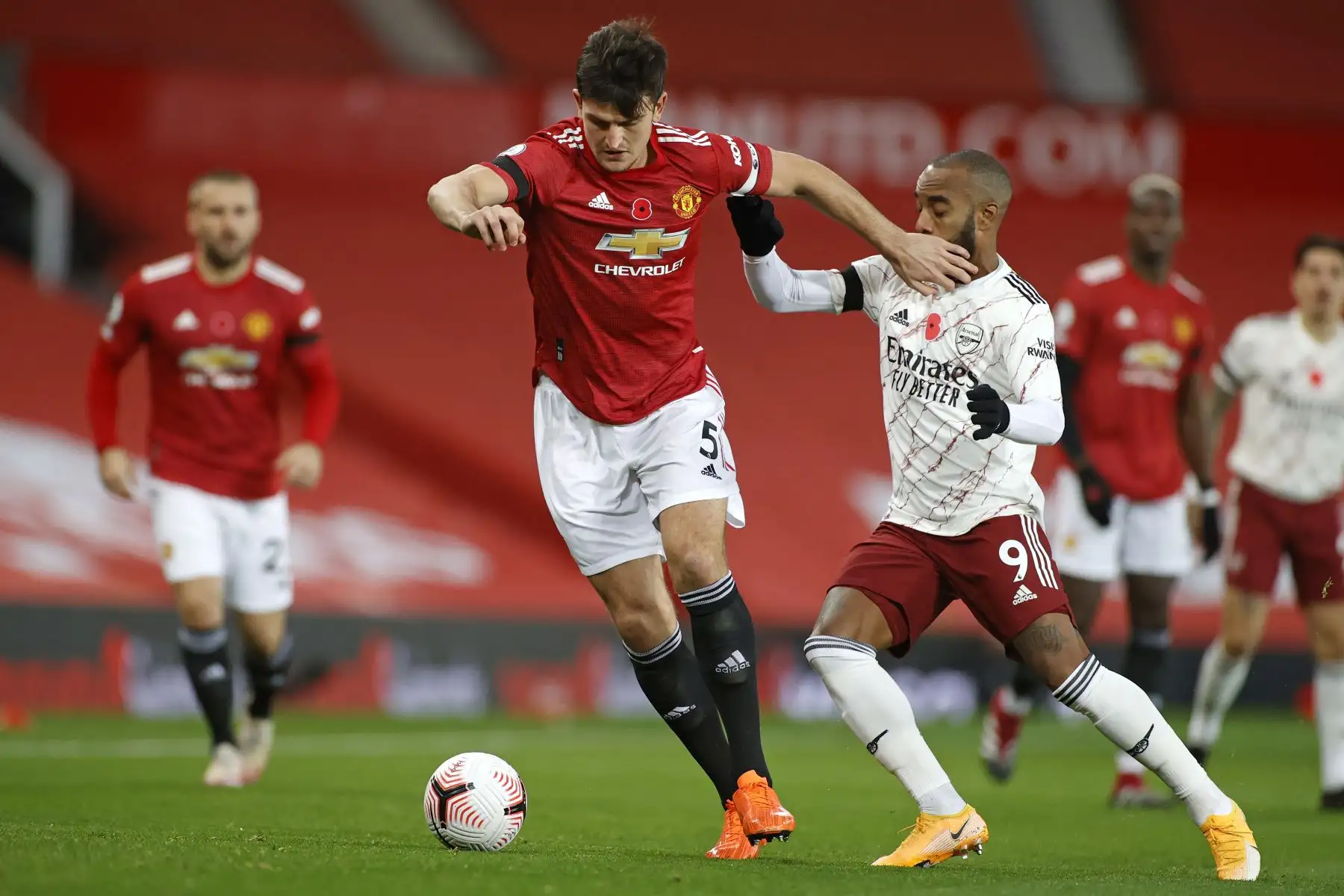El defensor inglés del Manchester United, Harry Maguire, compite con el delantero francés del Arsenal, Alexandre Lacazette, durante el partido de fútbol de la Premier League. Foto: AFP