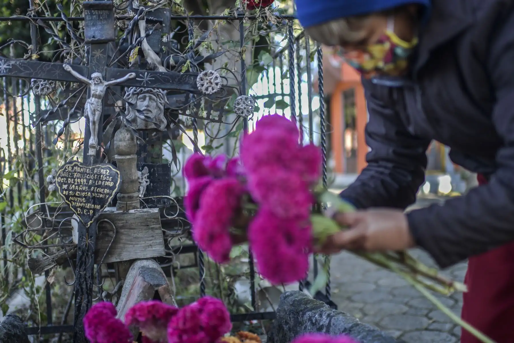 Una mujer decora la tumba de un familiar en el Panteón La Magdalena, en San Pedro Cholula, estado de Puebla, México, el 1 de noviembre de 2020, el Día de Todos los Santos, en medio de la pandemia del coronavirus. Foto: AFP