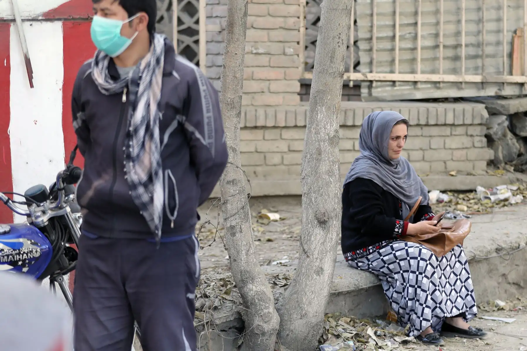 Una madre espera afuera a sus dos hijas atrapadas adentro de la Universidad después del ataque al centro de estudios, en Kabul, Afganistán. Foto: EFE