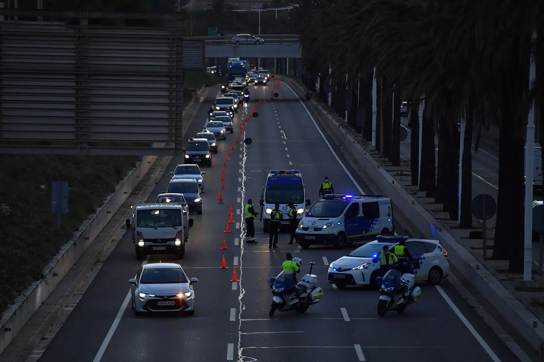 Los agentes de la policía municipal controlan los coches que salen de Barcelona cuando las regiones de España anunciaron cierres de fronteras regionales para evitar la propagación del coronavirus. Foto: AFP