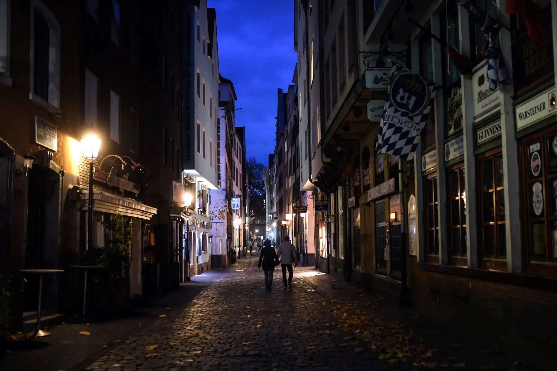 Personas transitan junto a bares y restaurantes cerrados en el casco antiguo de Colonia en Alemania, en medio de la pandemia del nuevo coronavirus. Foto: AFP