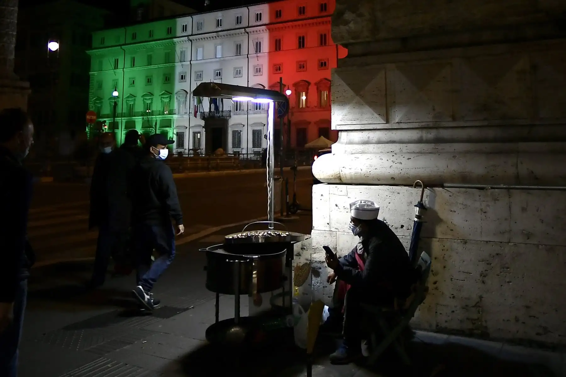 Un vendedor ambulante, con una mascarilla, ofrece sus productos cerca de la oficina gubernamental del Palazzo Chigi en Roma, Italia. Foto: AFP