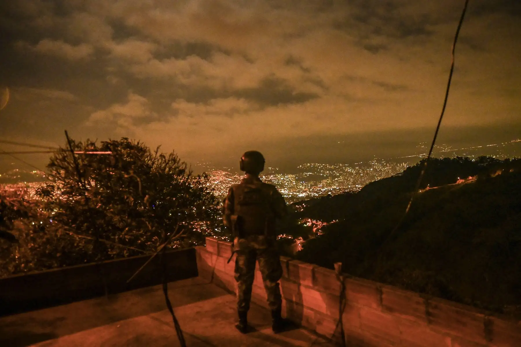 Un soldado hace guardia en el barrio Comuna 13 durante el toque de queda nocturno, en medio de la pandemia del Covid-19, en Medellín. Foto: AFP