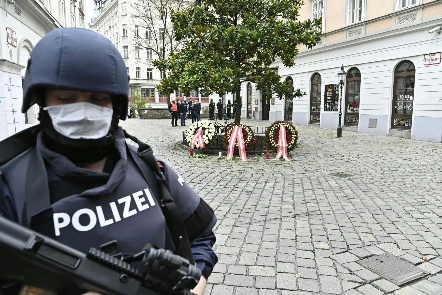 La policía monta guardia cerca de la escena del crimen donde se exhibieron coronas de flores para rendir homenaje a las víctimas del tiroteo, en Viena. Foto: AFP