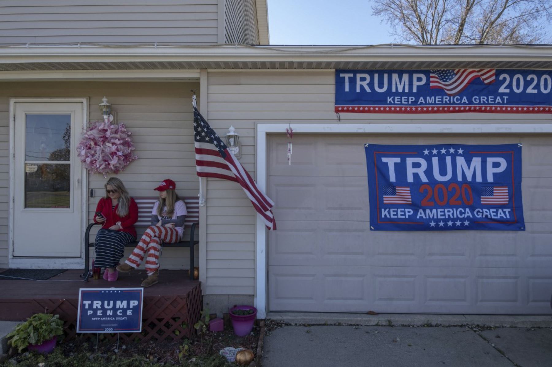 Partidarios del presidente de Estados Unidos, Donald Trump, se sientan en la puerta de su casa en Lansing, Michigan, el 3 de noviembre de 2020. Foto: AFP