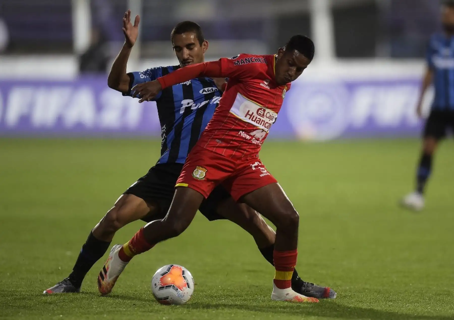 El uruguayo del Liverpool Andrés Pereira (izq.) Y el peruano Sport Huancayo Carlos Caraza compiten por el balón durante su partido de fútbol a puerta cerrada de la segunda ronda de la Copa Sudamericana en el Estadio Luis Franzini de Montevideo. Foto: AFP