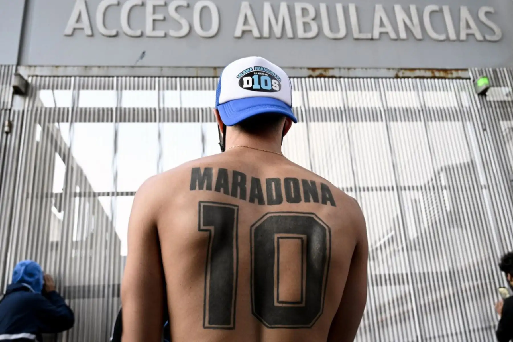 Un seguidor del exfutbolista argentino y entrenador de Gimnasia y Esgrima La Plata Diego Maradona muestra su tatuaje, frente al hospital donde fue sometido a una cirugía cerebral. 

Foto: AFP