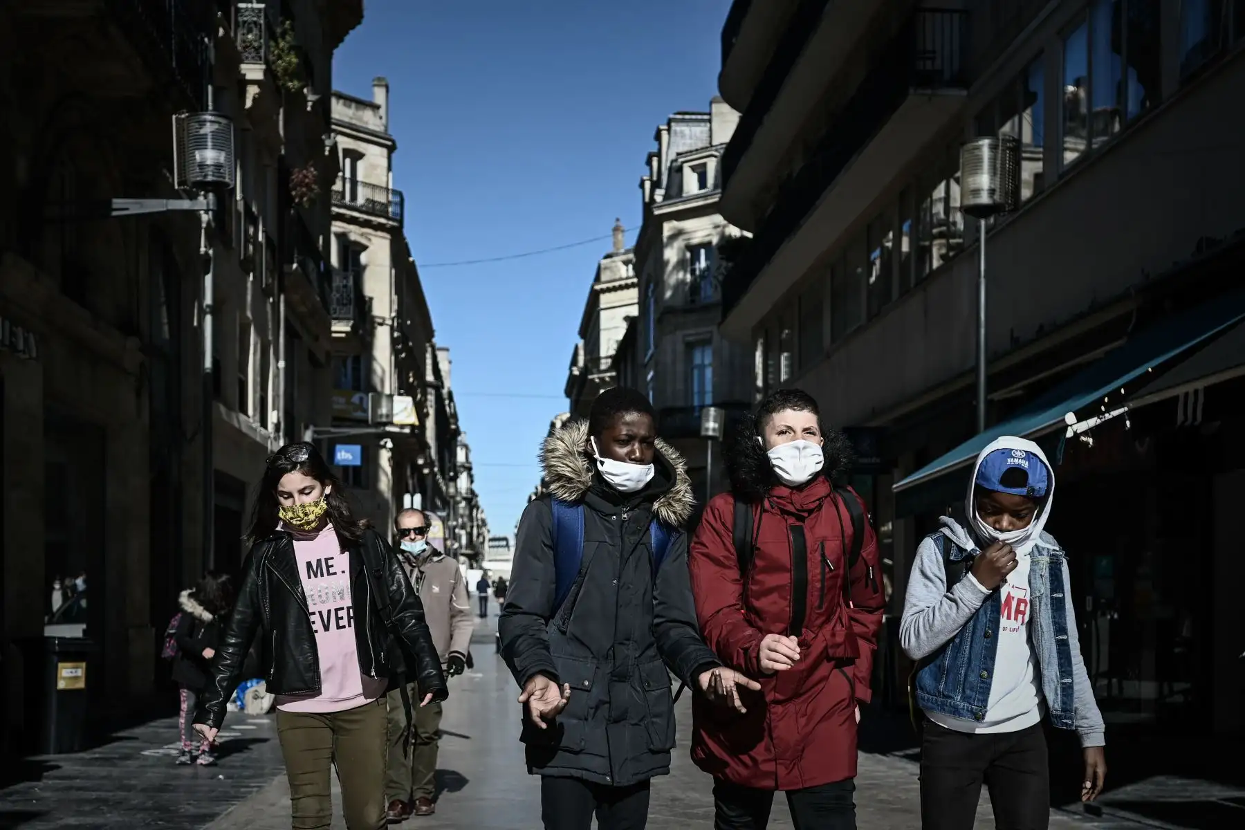 Los escolares que llevan máscaras protectoras pasan frente a las tiendas cerradas en una calle de Burdeos, en el suroeste de Francia.
Foto: AFP