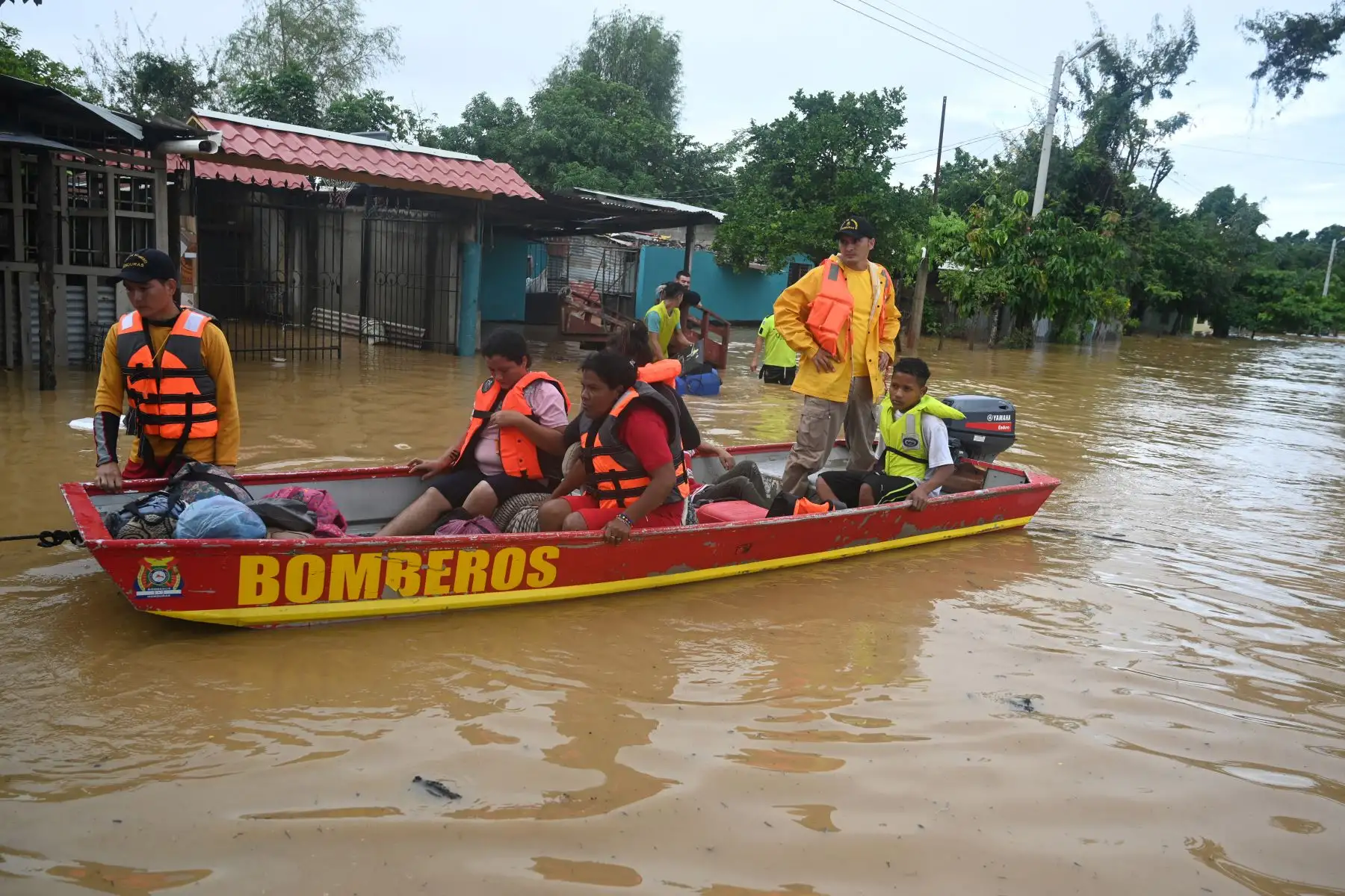 Bomberos rescatan a pobladores locales luego del desborde del río Ulúa en el municipio de El Progreso, departamento de Yoro, Honduras  debido a las fuertes lluvias provocadas por el huracán Eta.
Foto: AFP