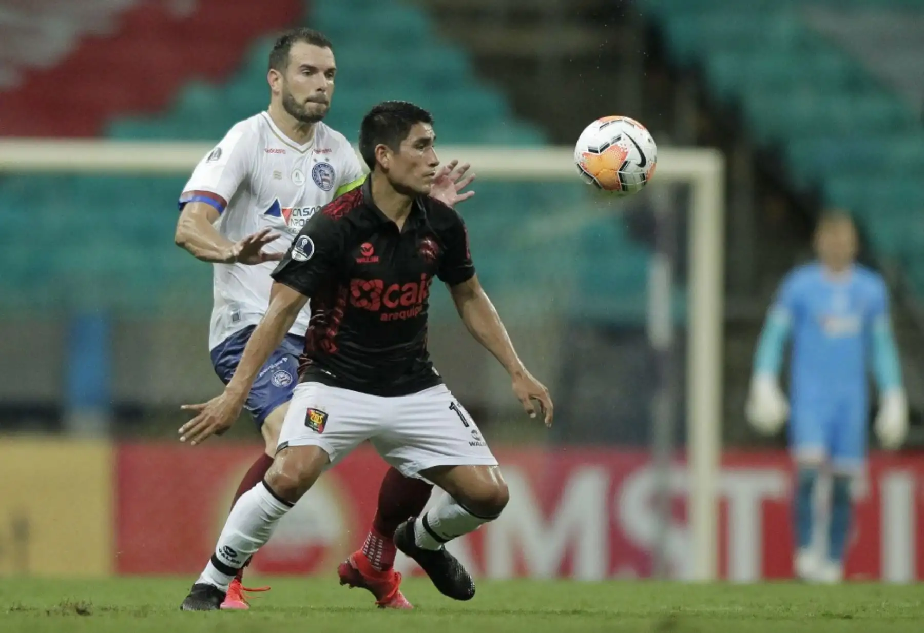 El brasileño del Bahia Lucas Fonseca (izq.) Y el peruano Melgar Irven Avila compiten por el balón durante su partido de fútbol a puerta cerrada de la segunda ronda de la Copa Sudamericana en el Fonte Nova Arena en Salvador, Brasil. Foto: AFP
