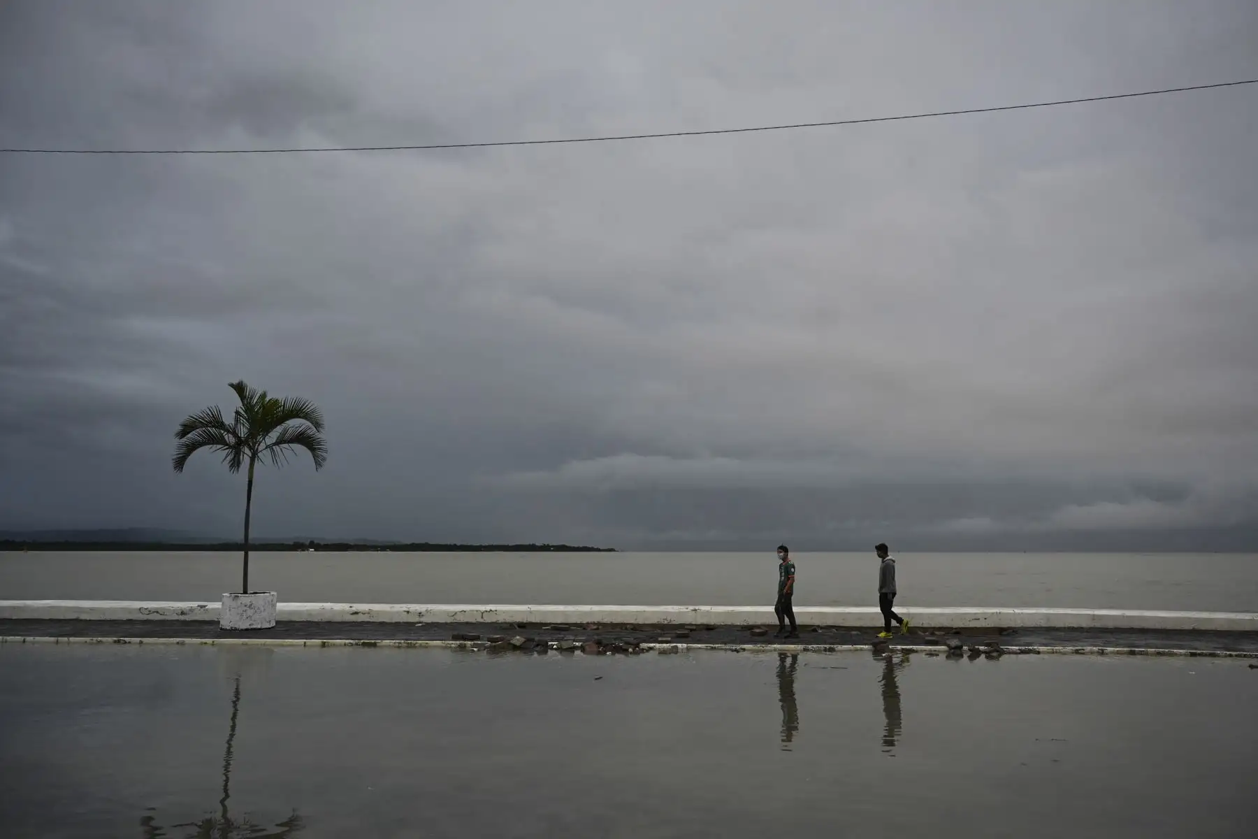 La gente camina por una calle inundada debido a las fuertes lluvias provocadas por el huracán Eta, ahora degradado a tormenta tropical, en Puerto Barrios, Izabal 310 km al norte de la Ciudad de Guatemala.
Foto: AFP