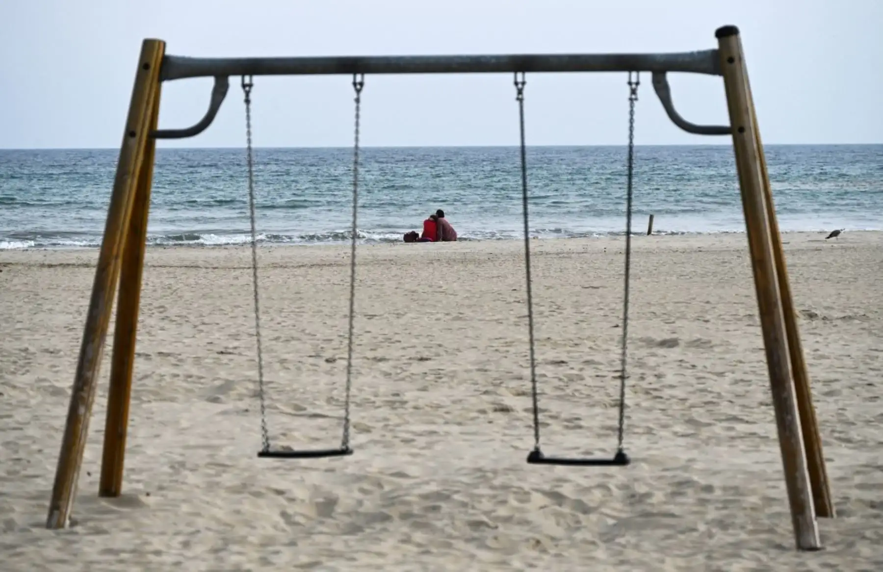 Una joven pareja mira al mar en una playa desierta el 6 de noviembre de 2020, en Palavas-les-Flots, cerca de Montpellier, en el sur de Francia, durante el cierre nacional destinado a contener la propagación del Covid-19. Foto: AFP