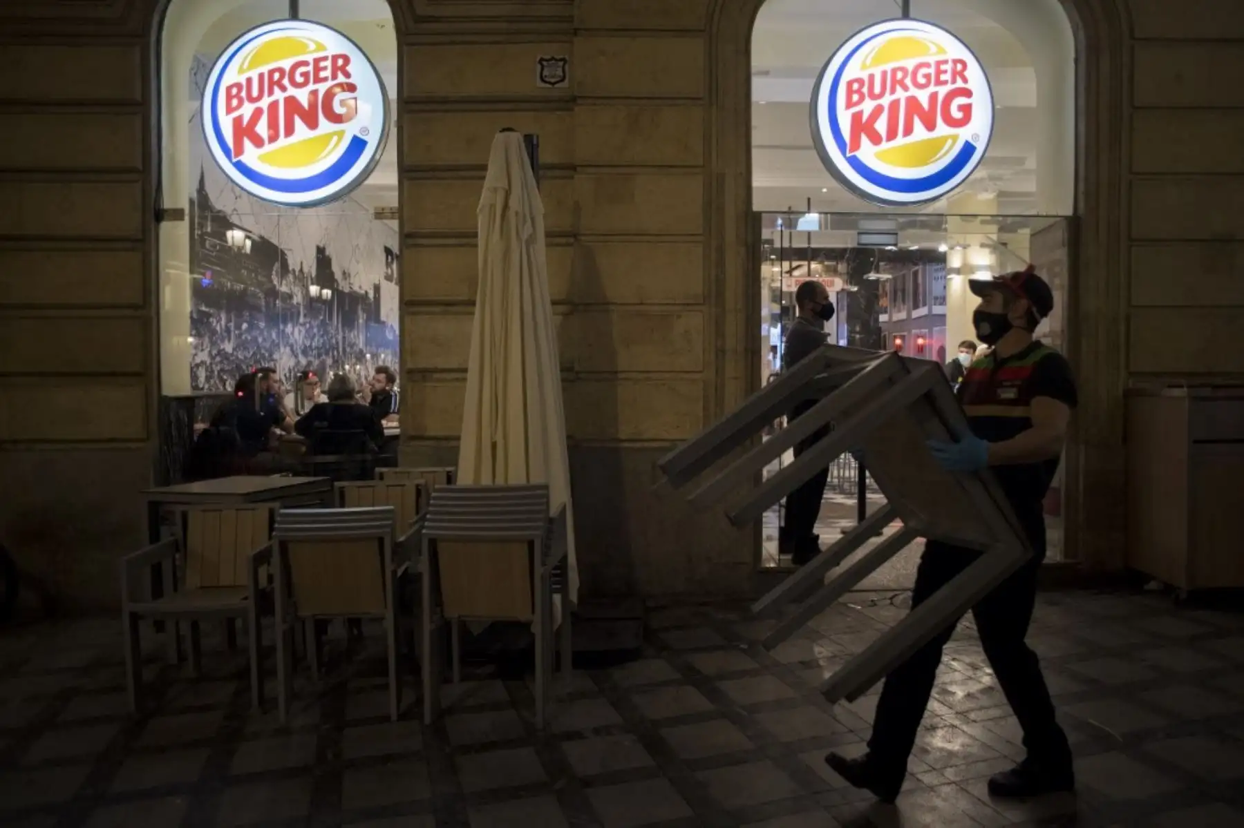 Los empleados se preparan para cerrar un restaurante al final de una jornada de trabajo en Granada. Foto: AFP