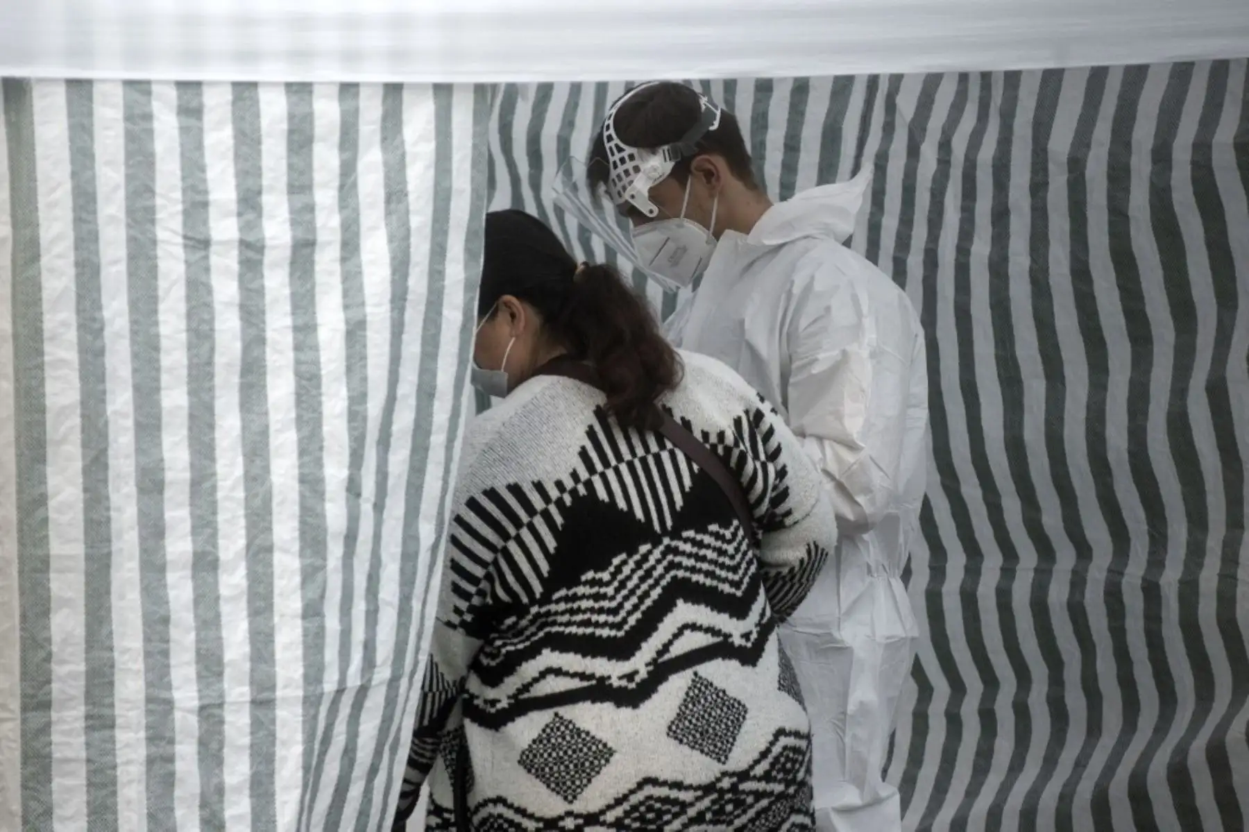Una mujer con una máscara facial camina para hacerse una prueba de COVID-19 en una estación de pruebas de coronavirus el 24 de septiembre de 2020 en Praga. Foto: AFP