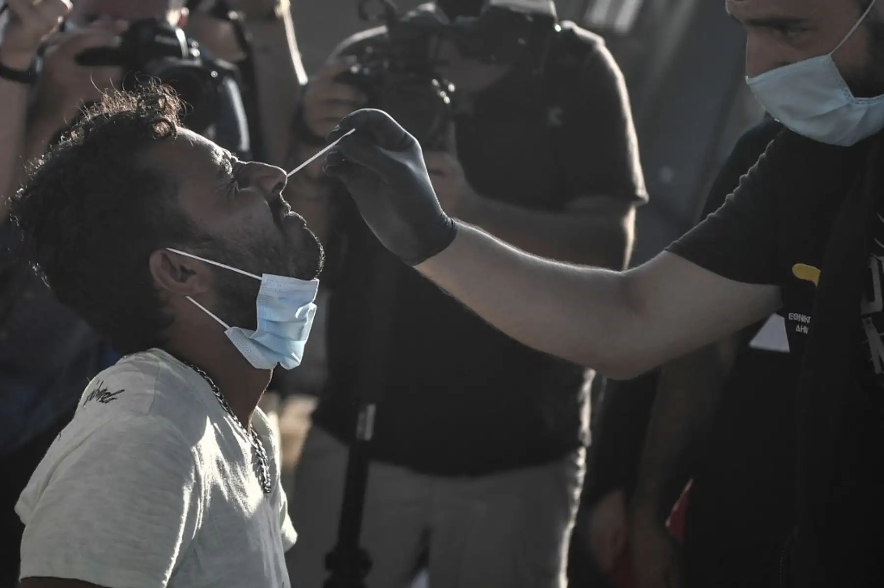 Un migrante se hace la prueba del nuevo coronavirus, Covid-19, en el nuevo campamento temporal donde los refugiados y migrantes del destruido campamento de Moria serán alojados en la isla griega de Lesbos. Foto: AFP