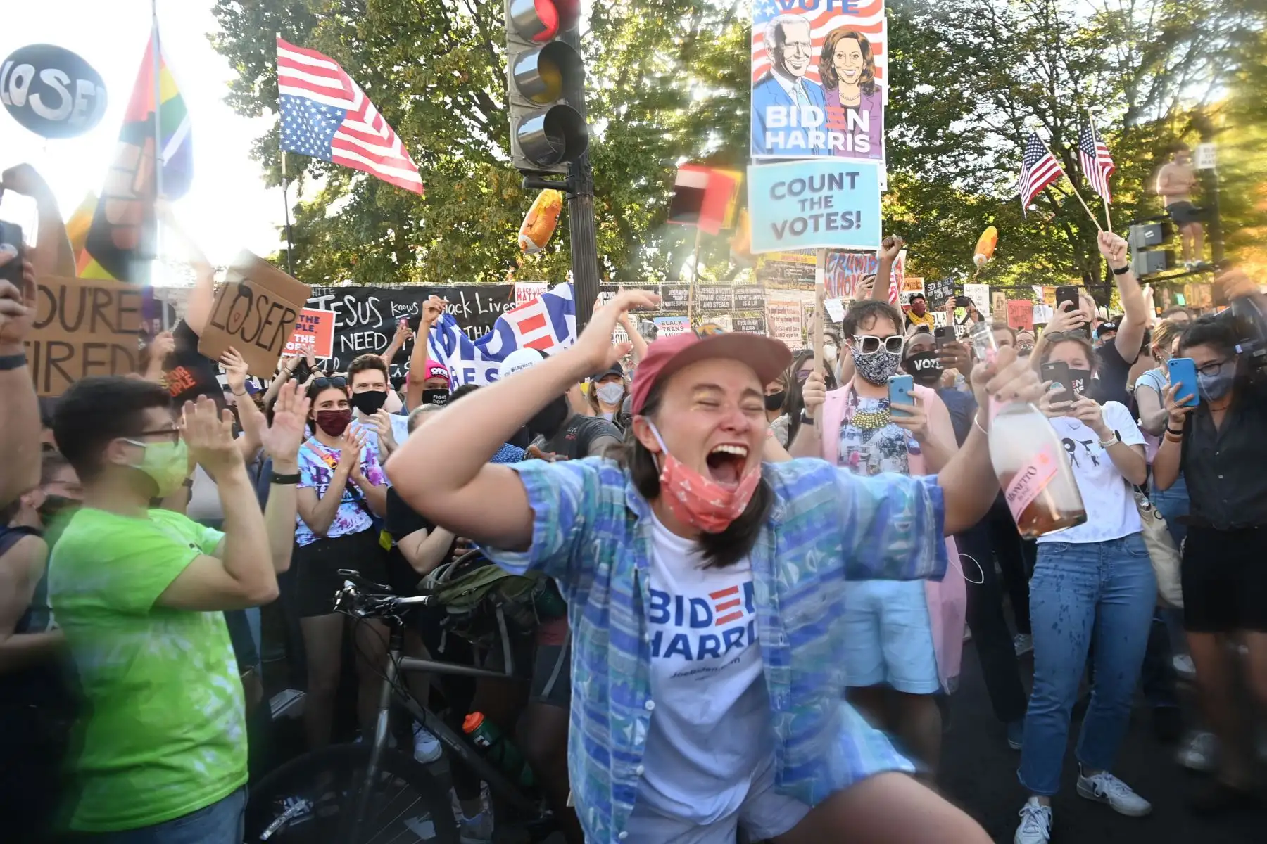 Una mujer baila frente a la Casa Blanca en Washington, DC el 7 de noviembre de 2020, después de que Joe Biden fuera declarado ganador de las elecciones presidenciales de 2020. Foto: AFP