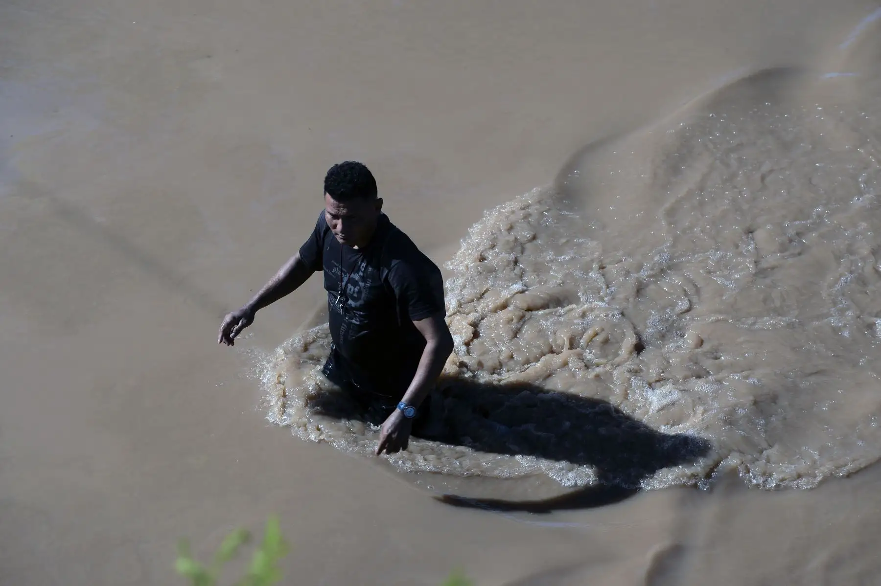 Un hombre vadea la carretera que conecta la ciudad de El Progreso, departamento de Yoro, con el municipio de La Lima, departamento de Cortés, en Honduras. Decenas de personas han muerto o siguen desaparecidas como restos del huracán Eta. 
Foto: AFP