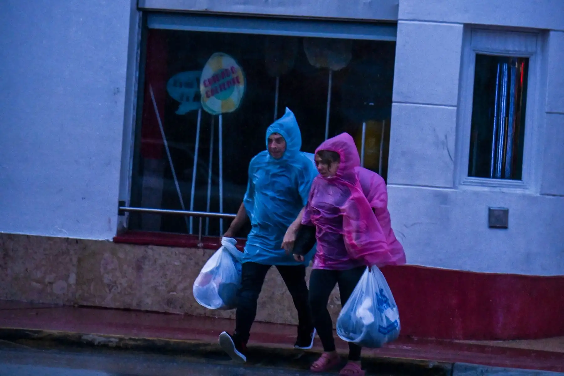 La gente cruza la calle durante las fuertes lluvias y el viento cuando la tormenta tropical Eta se acerca al sur de Florida, en Miami.
Foto: AFP