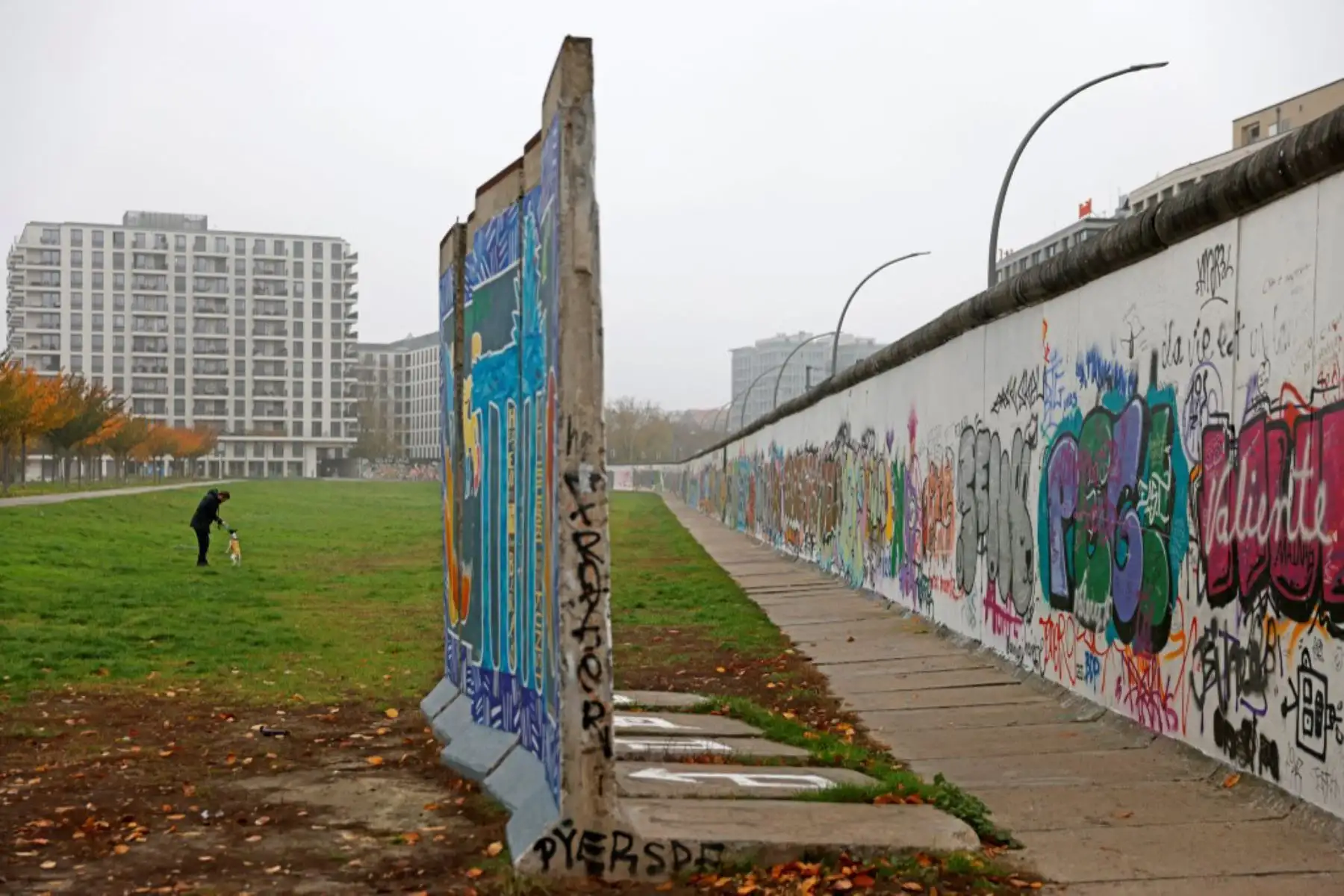 Un hombre juega con su perro a lo largo de un tramo de los restos del Muro de Berlín conocido como East Side Gallery en la capital alemana. Hoy es el 31 aniversario del día en que cayó el Muro de Berlín en 1989. El Muro de Berlín fue construido en 1961, en un momento en que Europa estaba dividida en dos y el muro mismo dividía la capital alemana de Berlín durante 28 años.

Foto: AFP