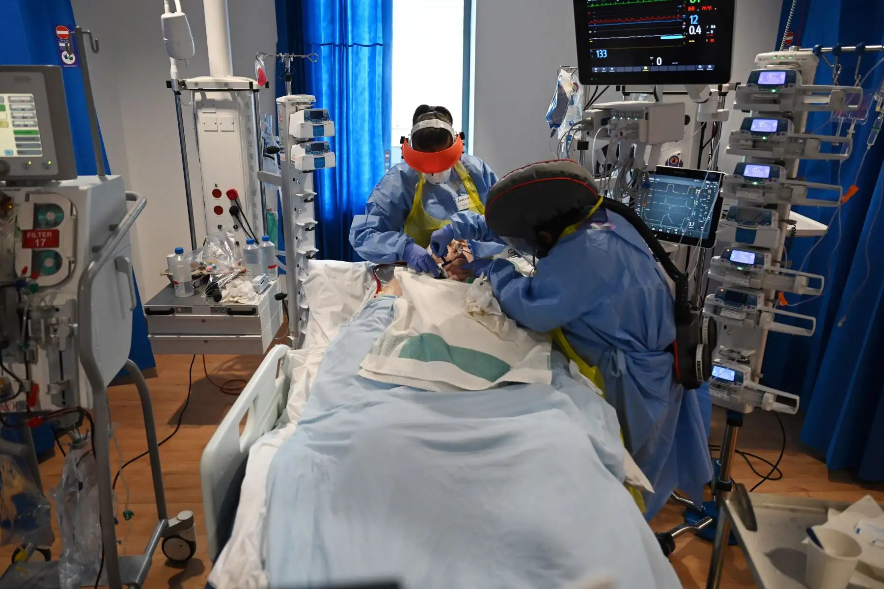 Los miembros del personal clínico usan equipo de protección personal (EPP) mientras atienden a un paciente en la unidad de cuidados intensivos del Royal Papworth Hospital en Cambridge, el 5 de mayo. Foto: AFP