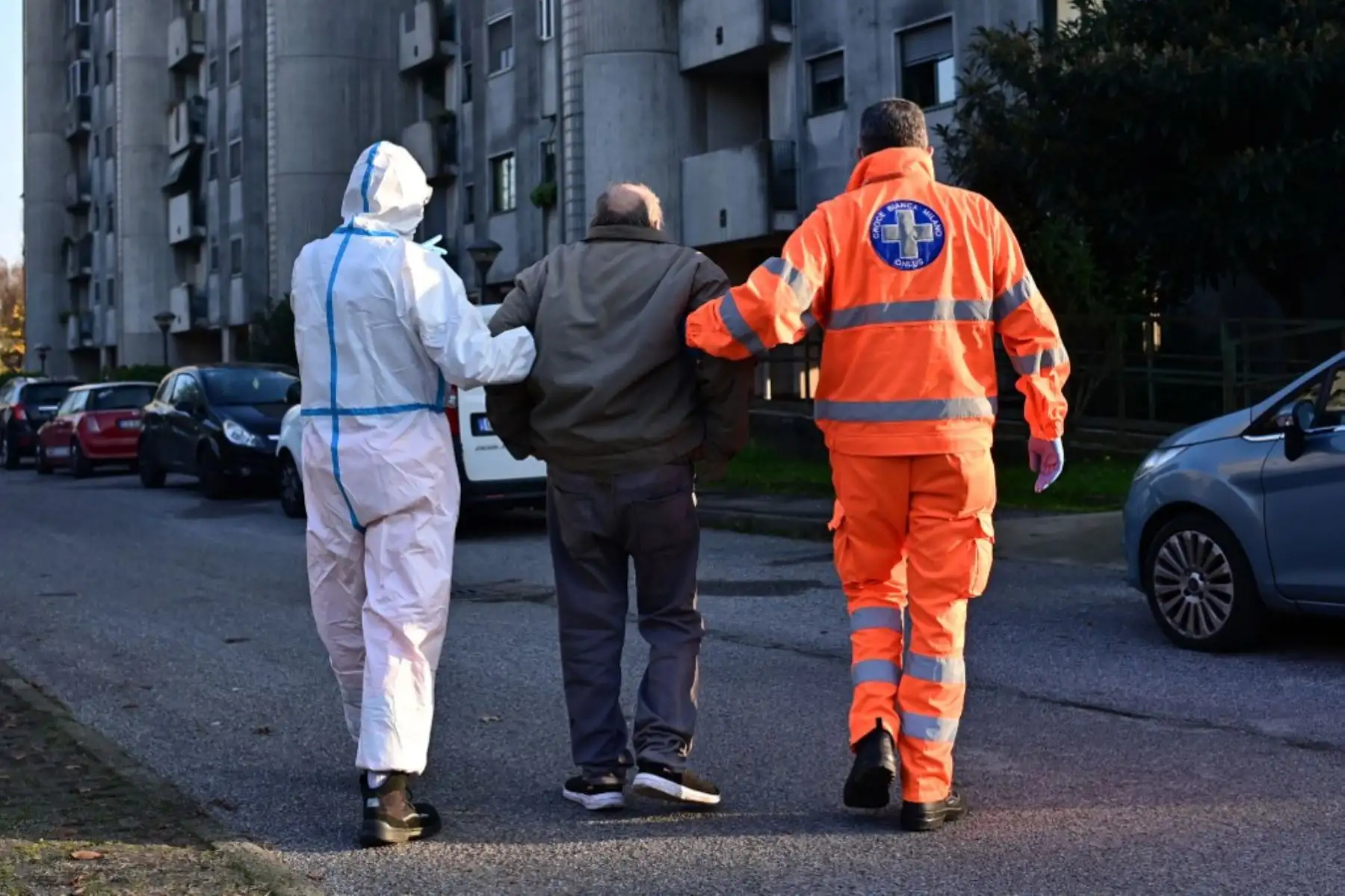 Trabajadores de emergencia de la Asociación Italiana Voluntaria de Primeros Auxilios y Asistencia Pública "Croce Bianca" escoltan a un jubilado después de una llamada de emergencia en Milán. Foto: AFP