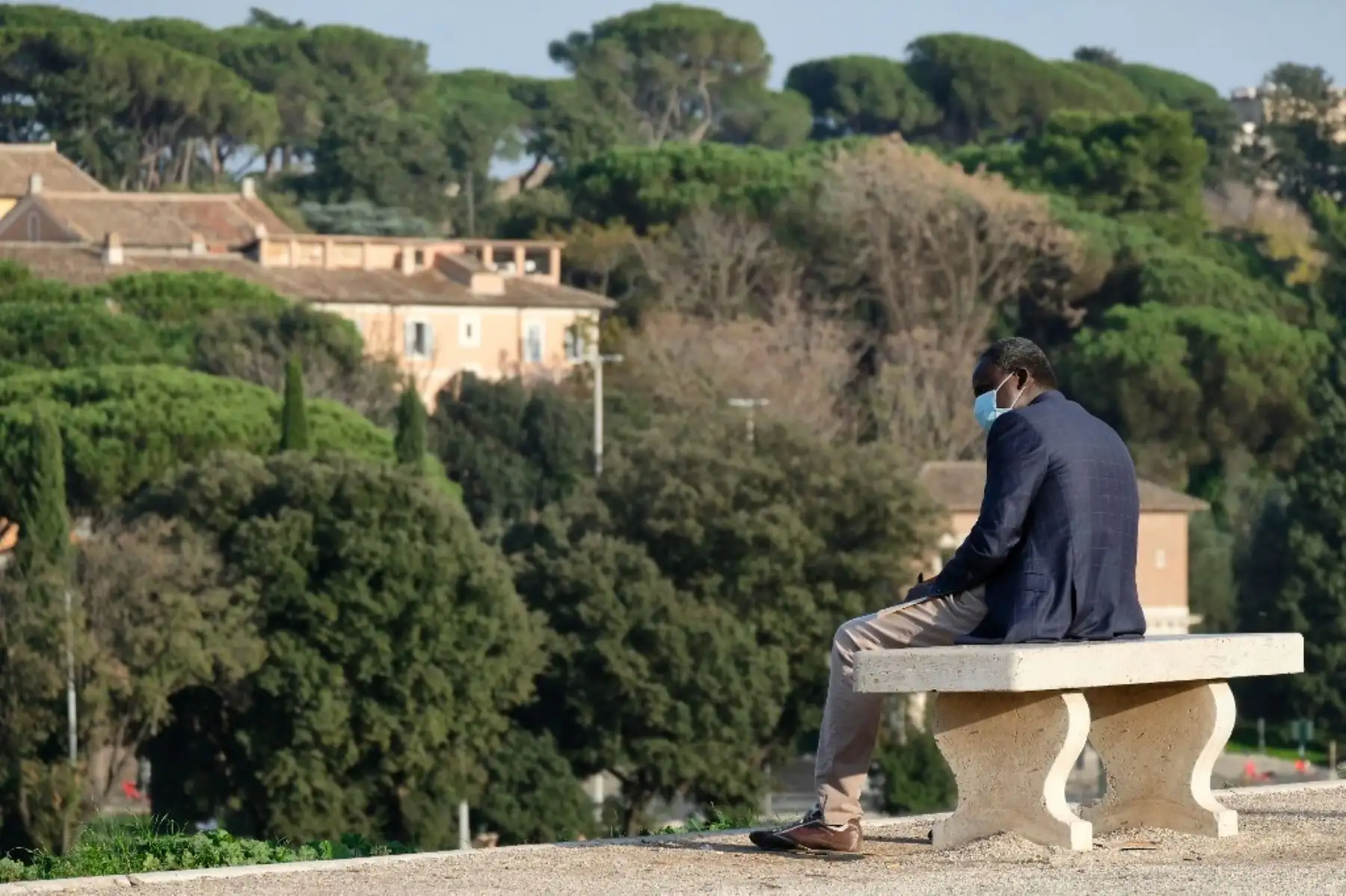 Un hombre que usa una máscara protectora se sienta en un banco público junto al Monte Palatino en Roma, durante las medidas de restricción del gobierno para frenar la propagación del nuevo coronavirus COVID-19. Foto: AFP