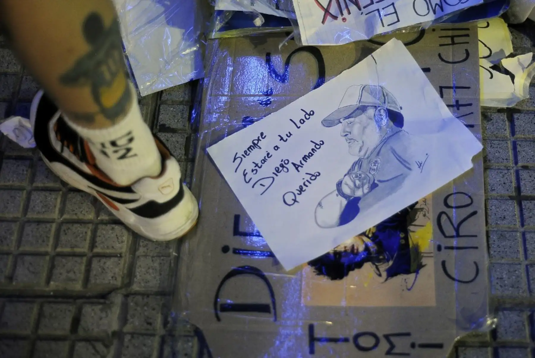 Vista de un papel que representa al ex astro del fútbol argentino y entrenador de Gimnasia y Esgrima La Plata, Diego Maradona, con la lectura “Siempre estaré contigo querido Diego Armando”, colocado por un aficionado en la acera de la clínica donde se sometió a una cirugía cerebral por una sangre. coágulo, en Olivos, provincia de Buenos Aires. Foto: AFP