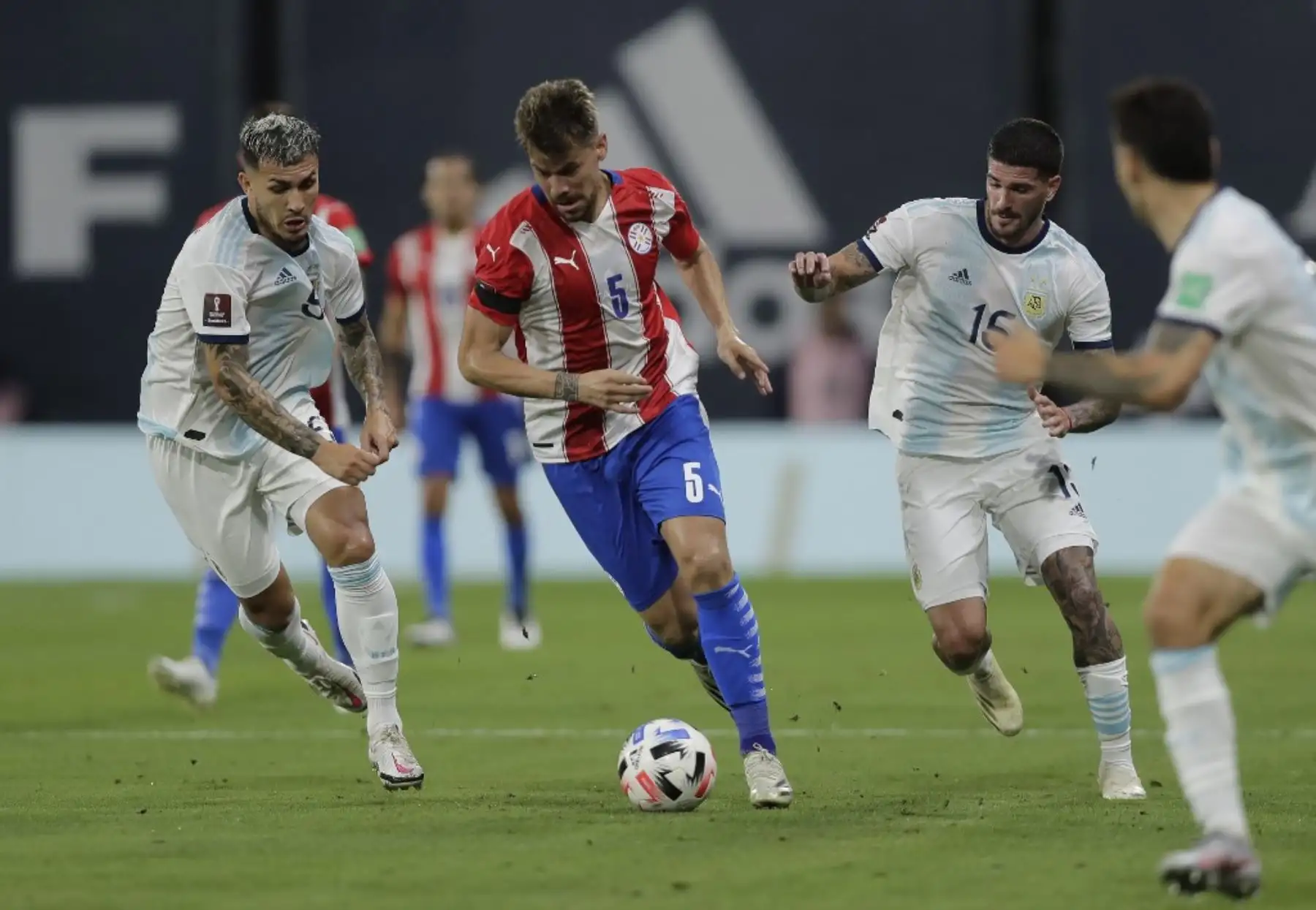 El paraguayo Gaston Gimenez (C) conduce el balón entre el argentino Leandro Paredes y el argentino Rodrigo De Paul durante su partido de fútbol a puerta cerrada clasificatorio sudamericano para la Copa Mundial de la FIFA 2022 en el Estadio La Bombonera de Buenos Aires. Foto: AFP