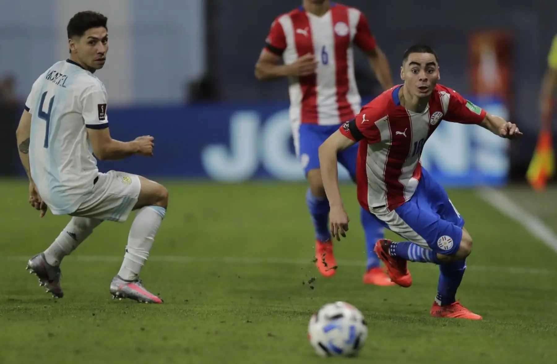 El argentino Gonzalo Montiel (izq.) y el paraguayo Miguel Almirón miran el balón durante su partido de fútbol a puerta cerrada clasificatorio sudamericano para la Copa Mundial de la FIFA 2022 en el estadio La Bombonera de Buenos Aires. Foto: AFP