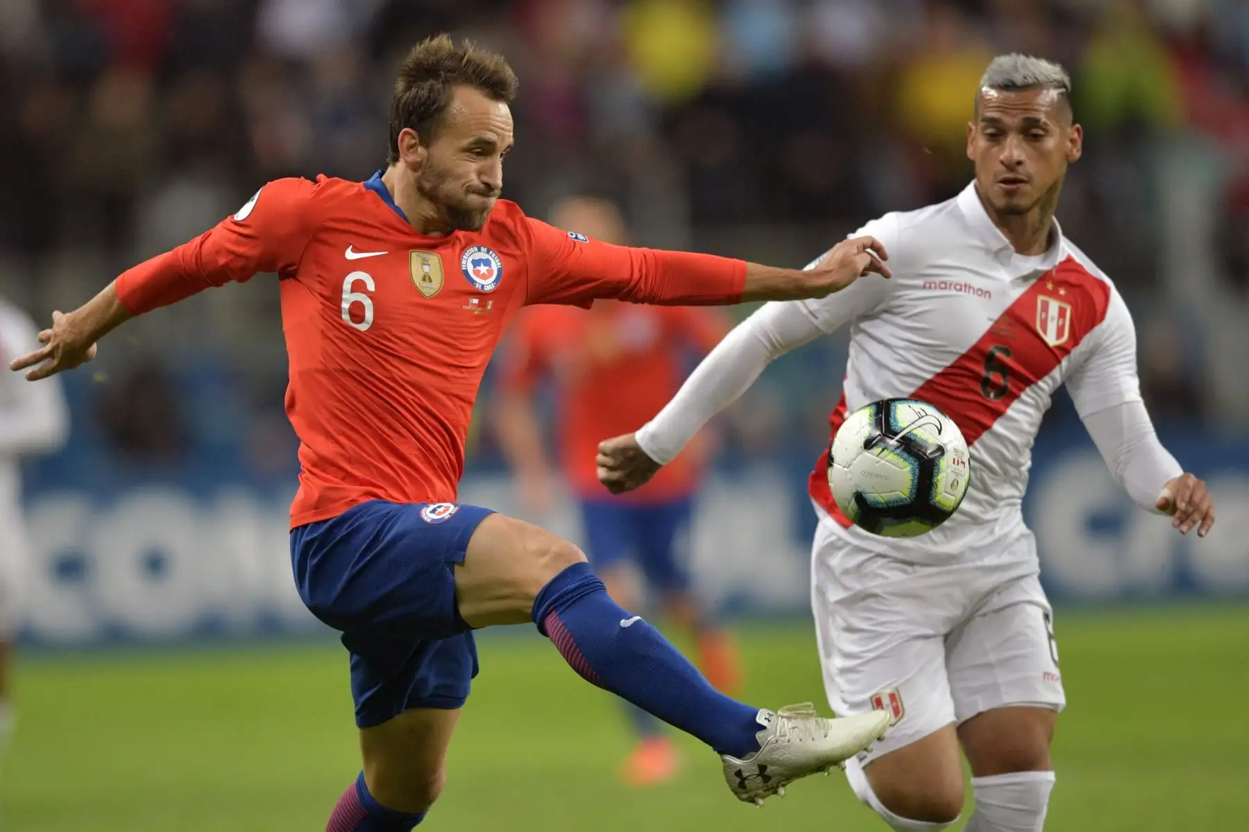 El chileno José Pedro Fuenzalida  y el peruano Miguel Trauco compiten por el balón durante la semifinal del torneo de fútbol de la Copa América en el Gremio Arena de Porto Alegre, Brasil, el 3 de julio de 2019.