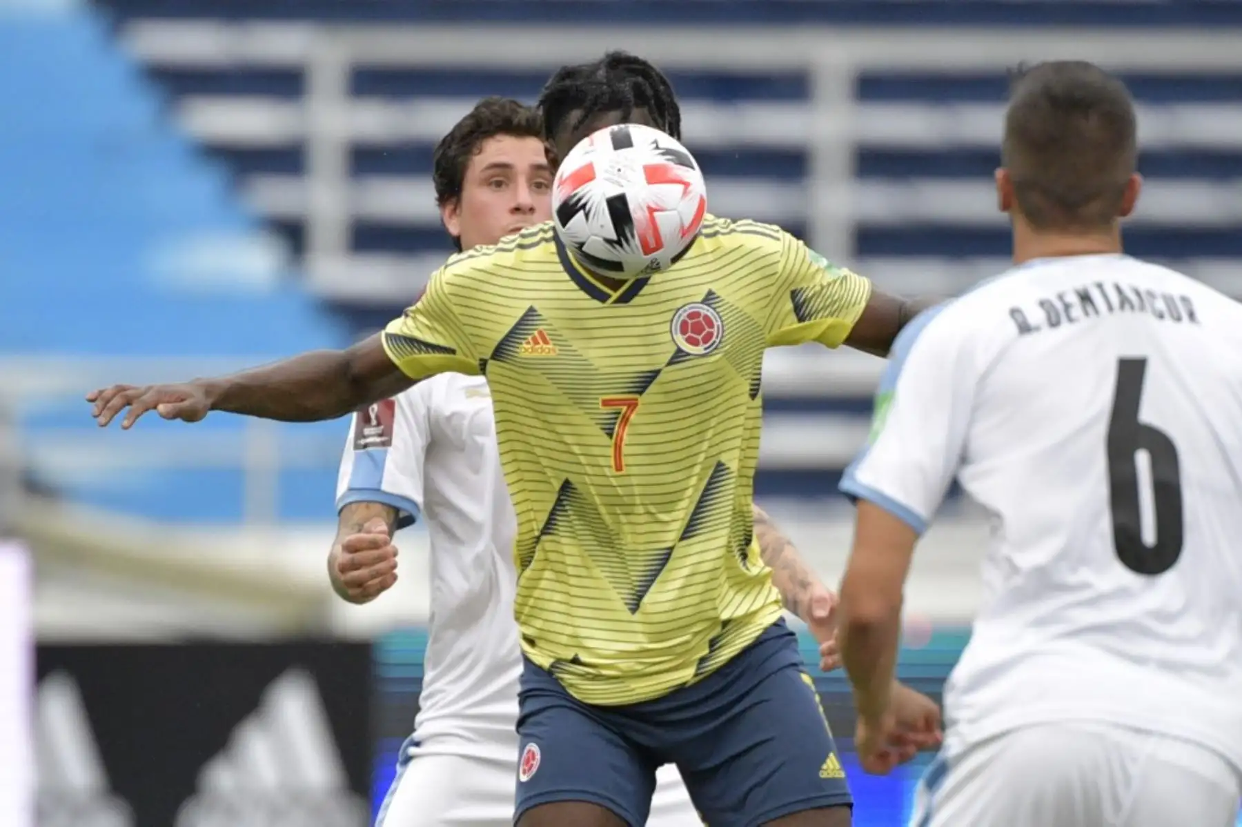 El colombiano Duvan Zapata (centro) está marcado por los uruguayos José María Giménez (izq.) y Rodrigo Bentancur durante su partido de fútbol a puerta cerrada clasificatorio sudamericano para la Copa Mundial de la FIFA 2022 en el Estadio Metropolitano de Barranquilla, Colombia. Foto: AFP