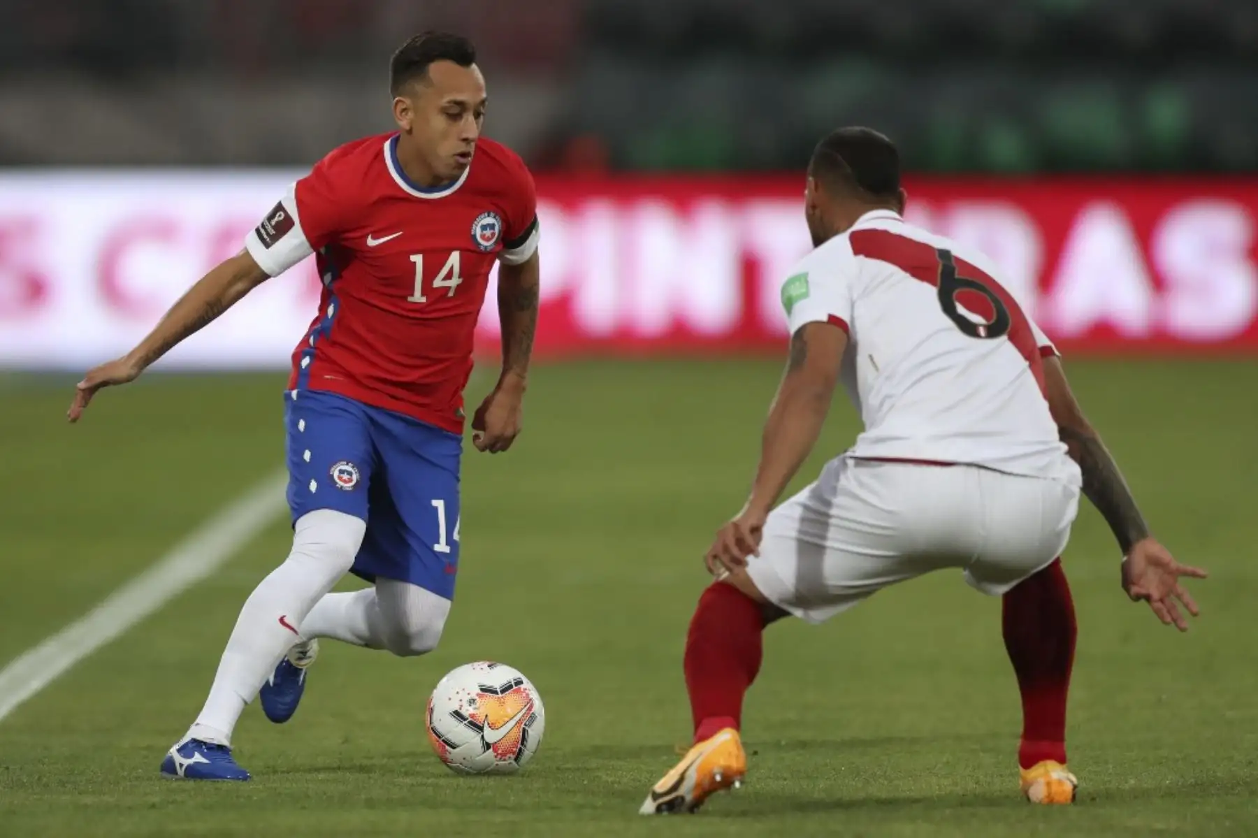 El chileno Fabián Orellana (izq.) Está marcado por el peruano Miguel Trauco durante su partido de fútbol a puertas cerradas clasificatorio sudamericano para la Copa Mundial de la FIFA 2022 en el Estadio Nacional de Santiago. Foto: AFP