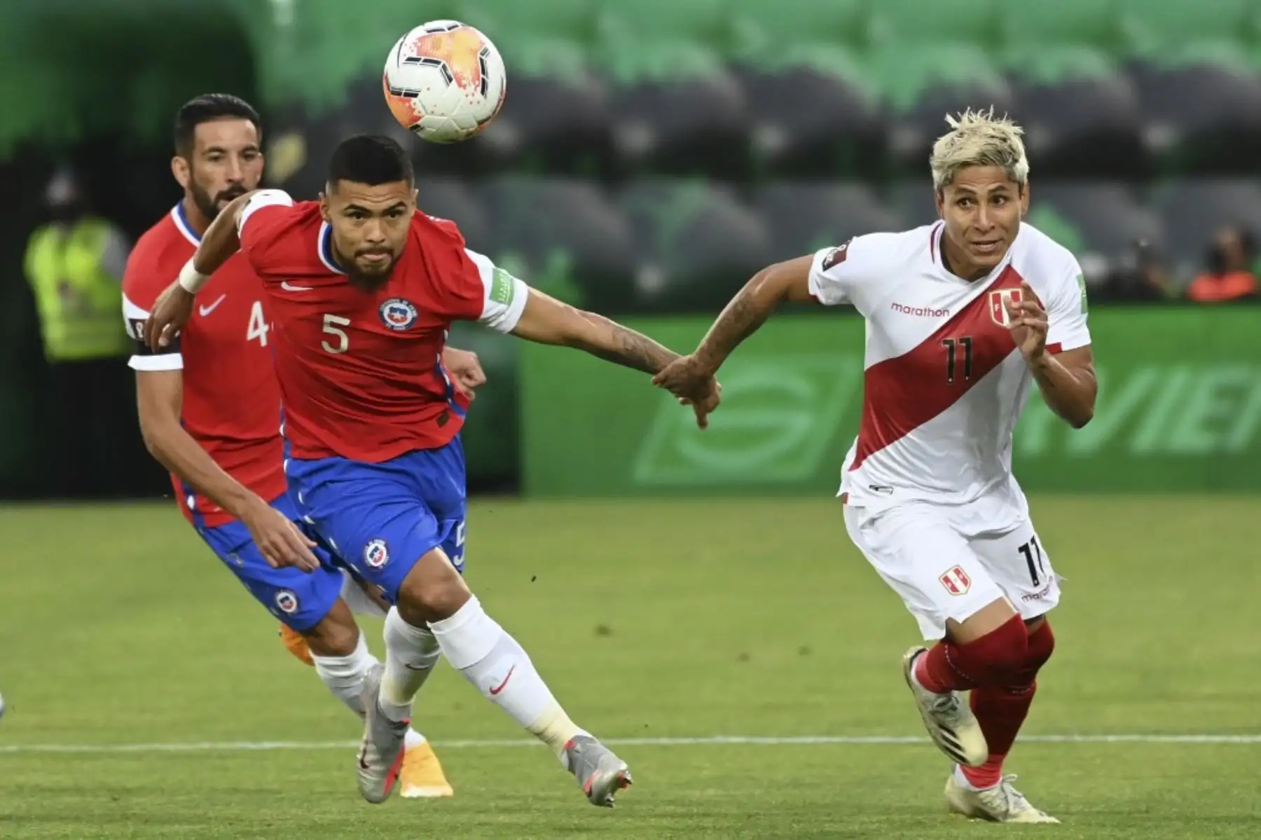 El chileno Paulo Díaz (izq.) Y el peruano Raúl Ruidiaz compiten por el balón durante su partido de fútbol a puertas cerradas clasificatorio sudamericano para la Copa Mundial de la FIFA 2022 en el Estadio Nacional de Santiago. Foto: AFP