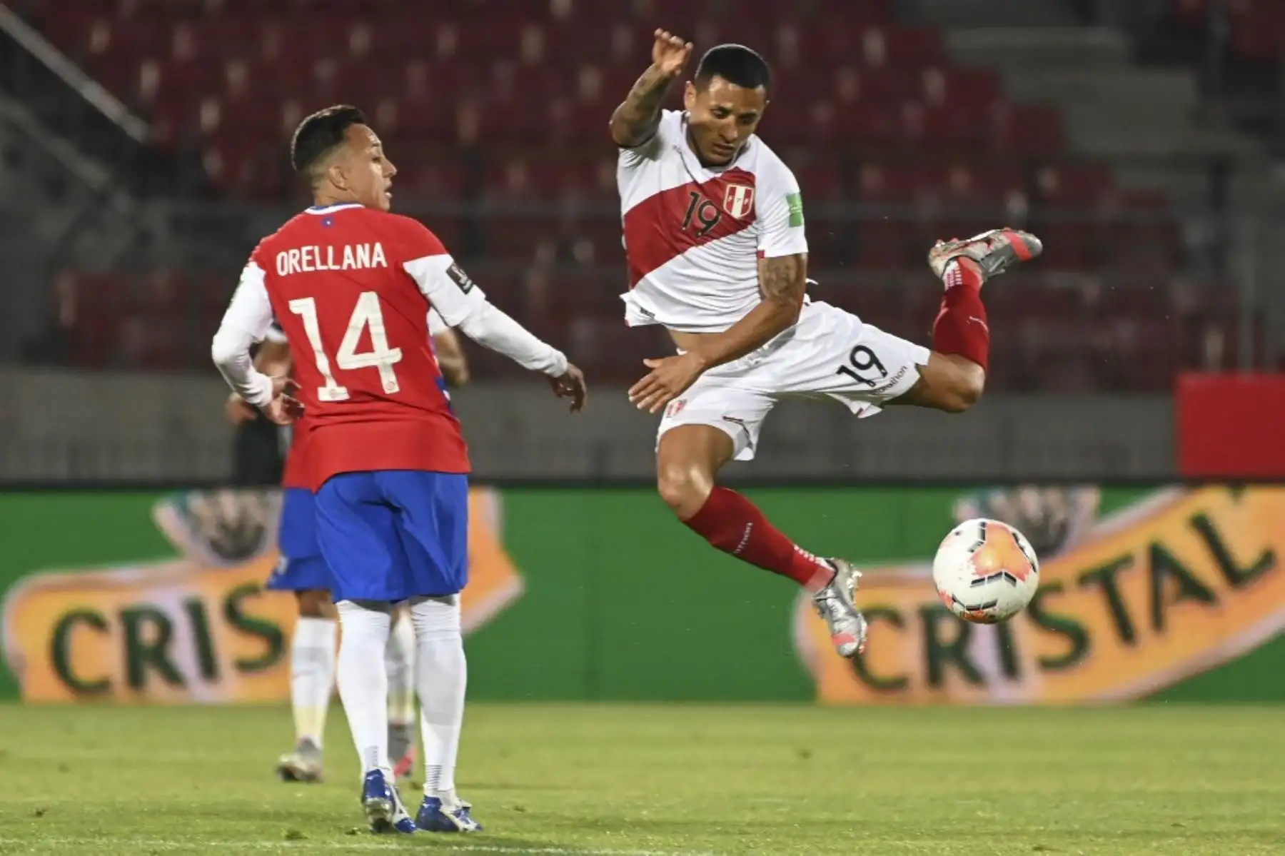 El chileno Fabián Orellana (izq.) Y el peruano Yoshimar Yotun compiten por el balón durante su partido de fútbol a puerta cerrada clasificatorio sudamericano para la Copa Mundial de la FIFA 2022 en el Estadio Nacional de Santiago. Foto: AFP